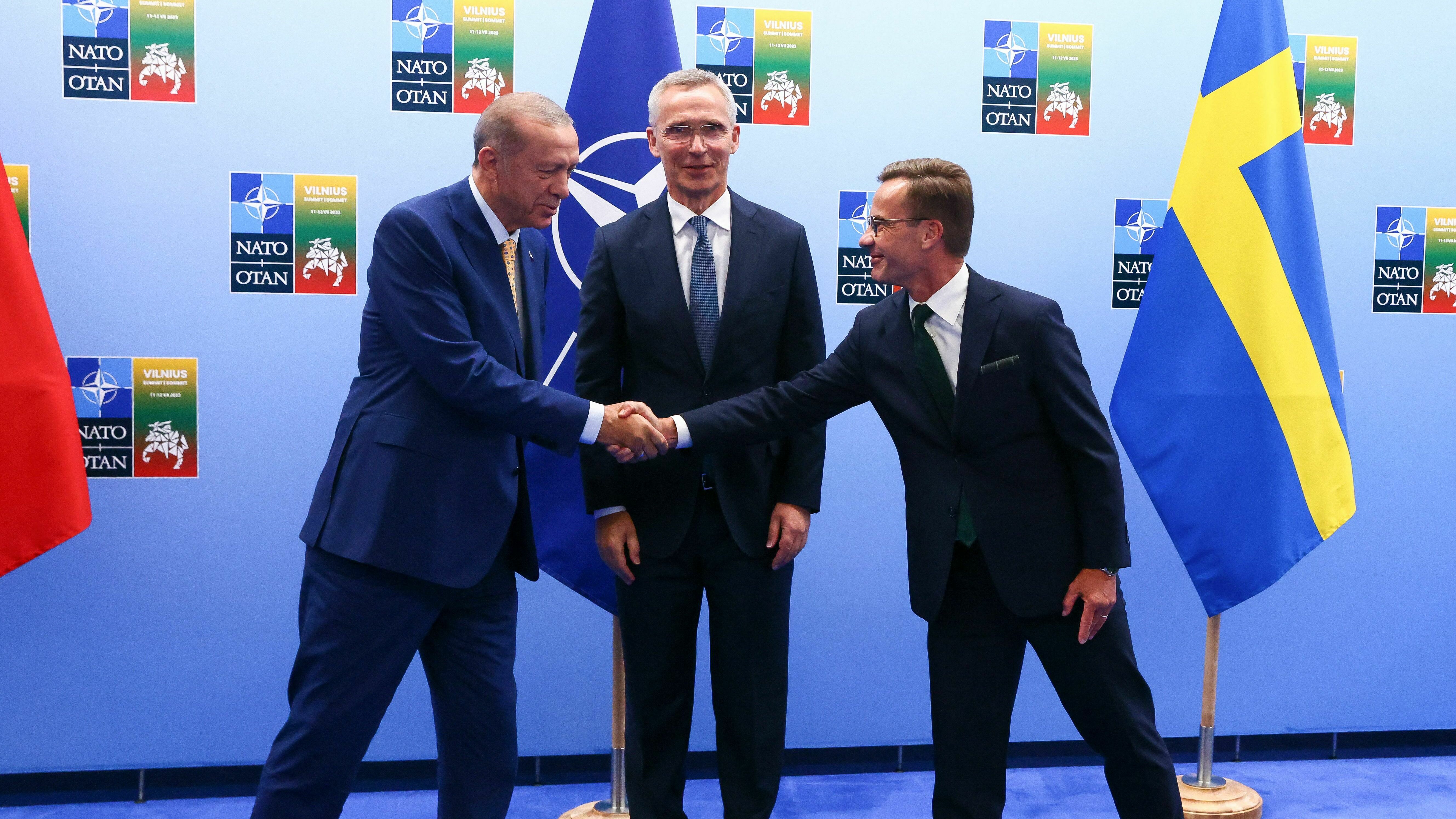 Turkish President Tayyip Erdogan (L) and Swedish Prime Minister Ulf Kristersson shake hands next to NATO Secretary-General Jens Stoltenberg prior to their meeting in Vilnius on Monday.