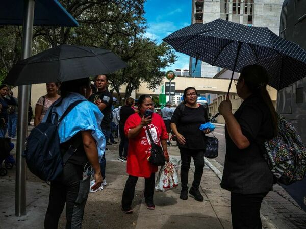 Staying out of direct sun as much as possible can help prevent heat-related illness. Look for shade or make your own with an umbrella, like these pedestrians waiting for a bus during a heat wave in Miami on June 26.