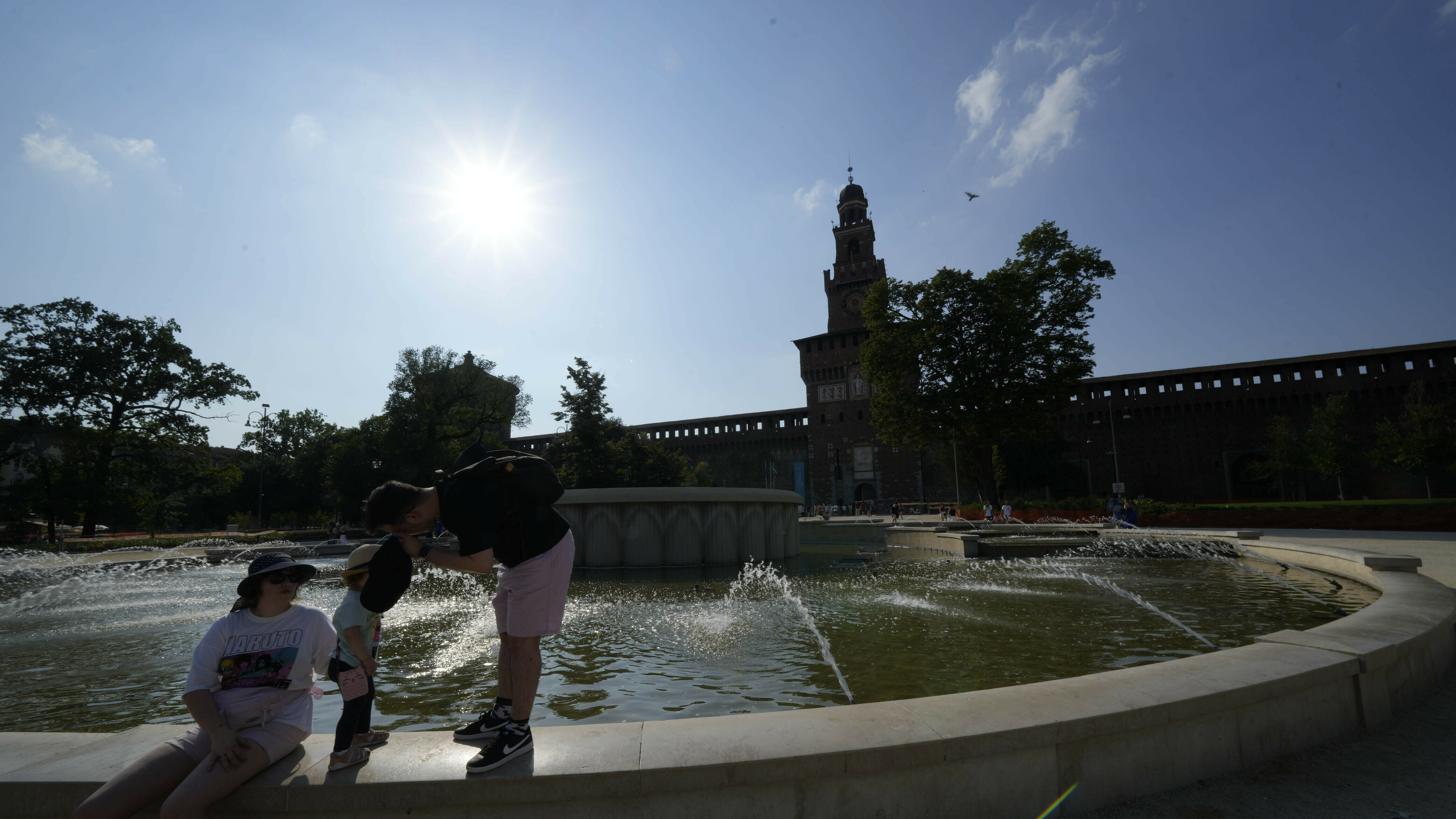Tourists cool off in a public fountain at the Sforzesco Castle, in Milan, Italy, on Saturday. Temperatures reached up to 42 degrees Celsius in some parts of the country, amid a heat wave that continues to grip southern Europe.