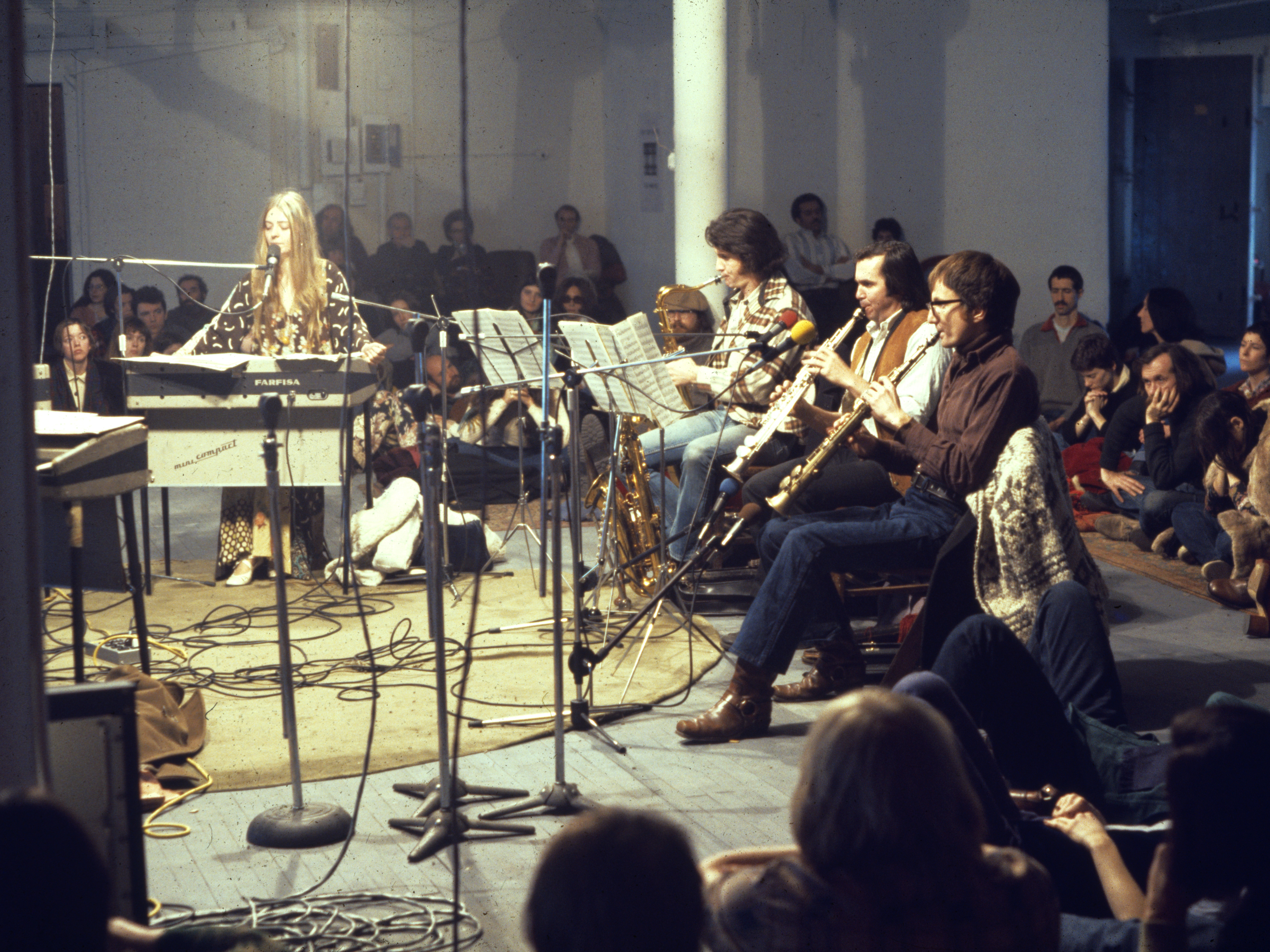 The Philip Glass Ensemble performing Music in Twelve Parts at the Idea Warehouse in 1975, with vocalist Joan La Barbara (far left). (SCALA/Art Resource, N.Y.)