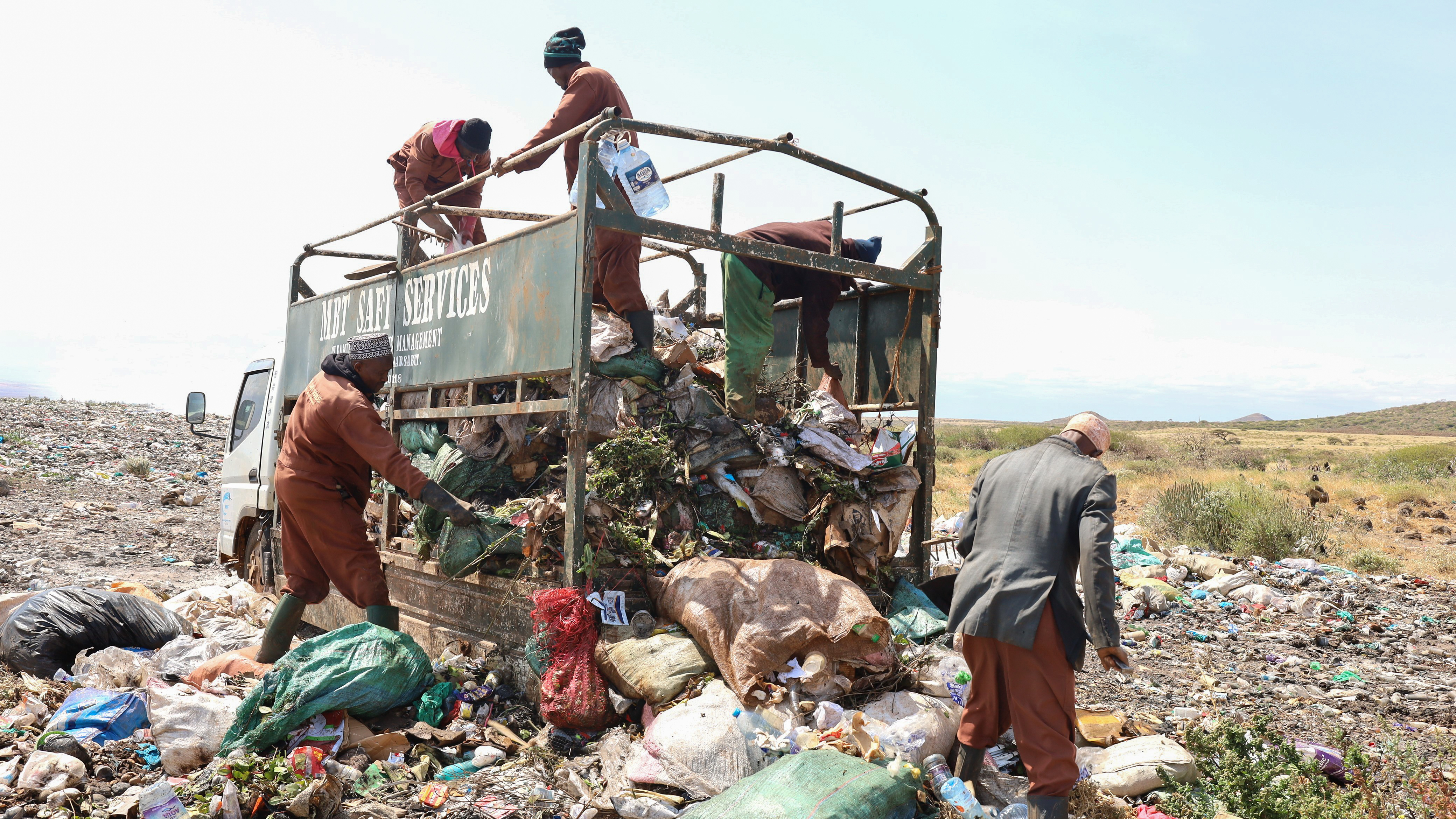 Trash collectors from Marsabit Safi Services offload waste at the Dadach Boshe dump. Even though Kenyan banned single-use plastic bags in 2016, they