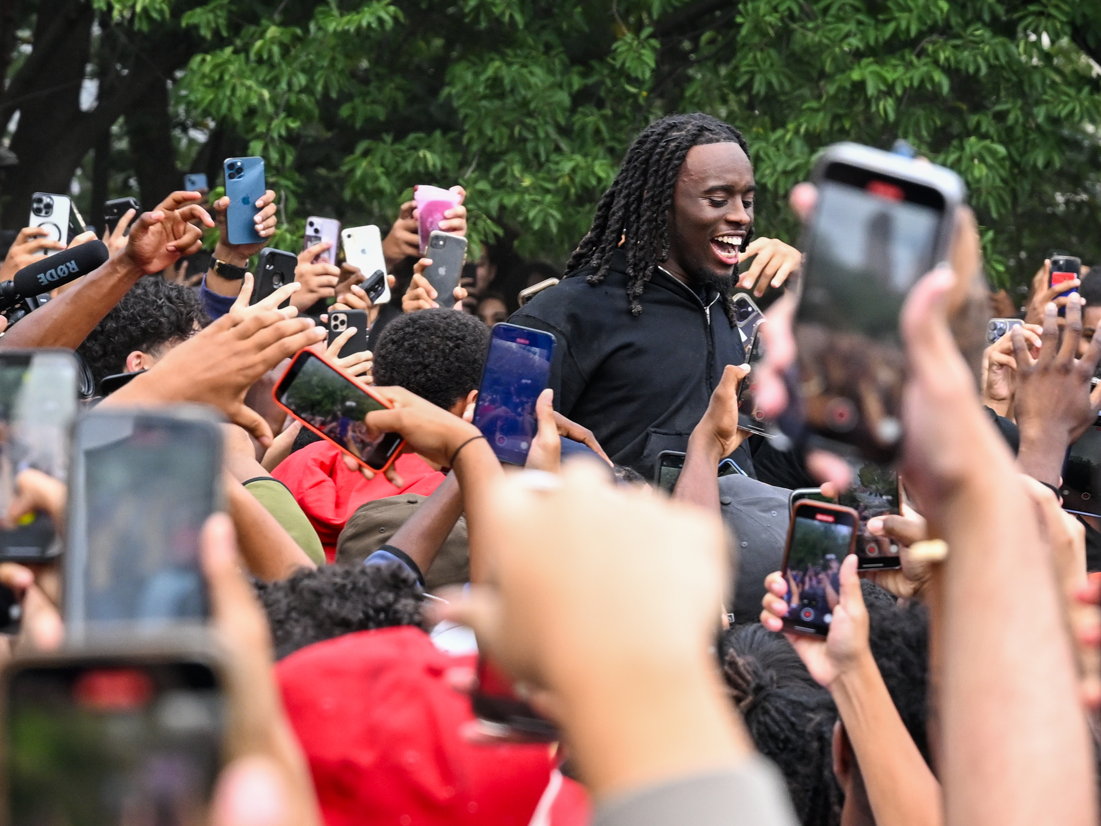 People gather around and cheer for Kai Cenat during the meetup that eventually resulted in dozens of arrests and several injuries. (Getty Images)