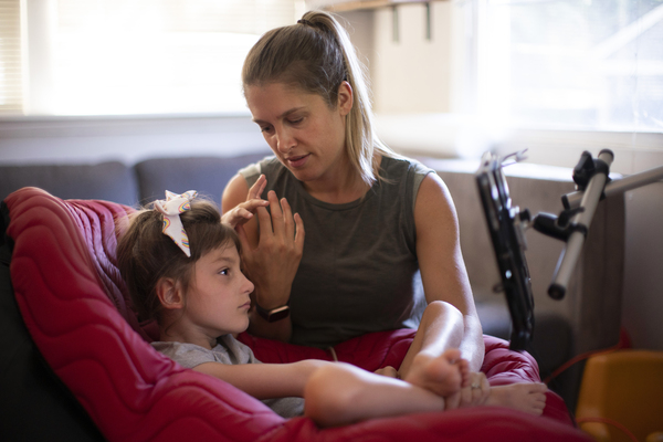 Jenny Eckart Hoyt directs her daughter Winnie's attention to an "eye gaze" device in their Portland, Ore., home. The communication skills the eye gaze can unlock are critical for Winnie's educational future. To master it, Winnie needs a lot of practice with a trained instructor.