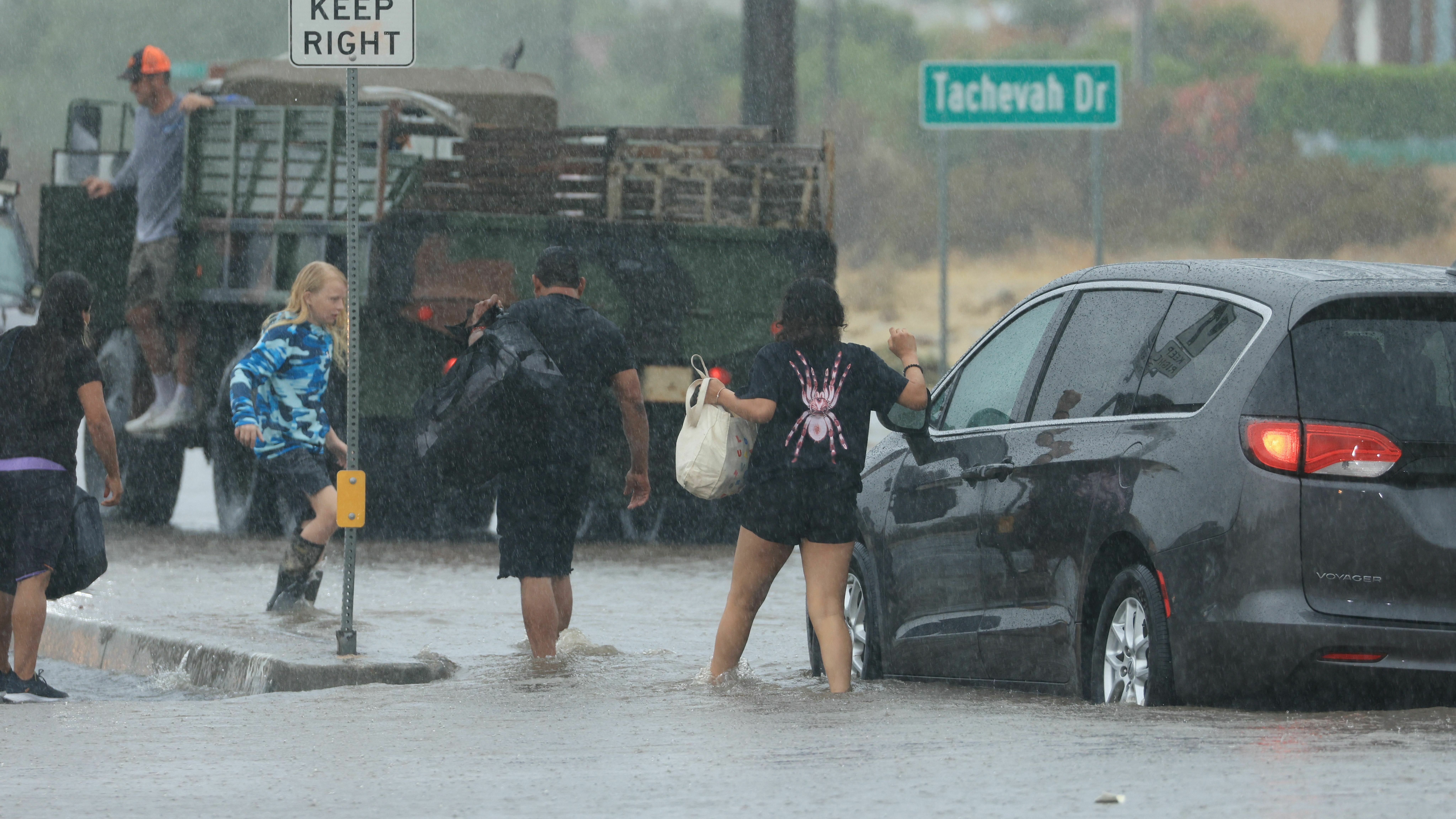 Motorists leave their vehicle stuck on a flooded road during heavy rains from Tropical Storm Hilary in Palm Springs, Calif., on Sunday.