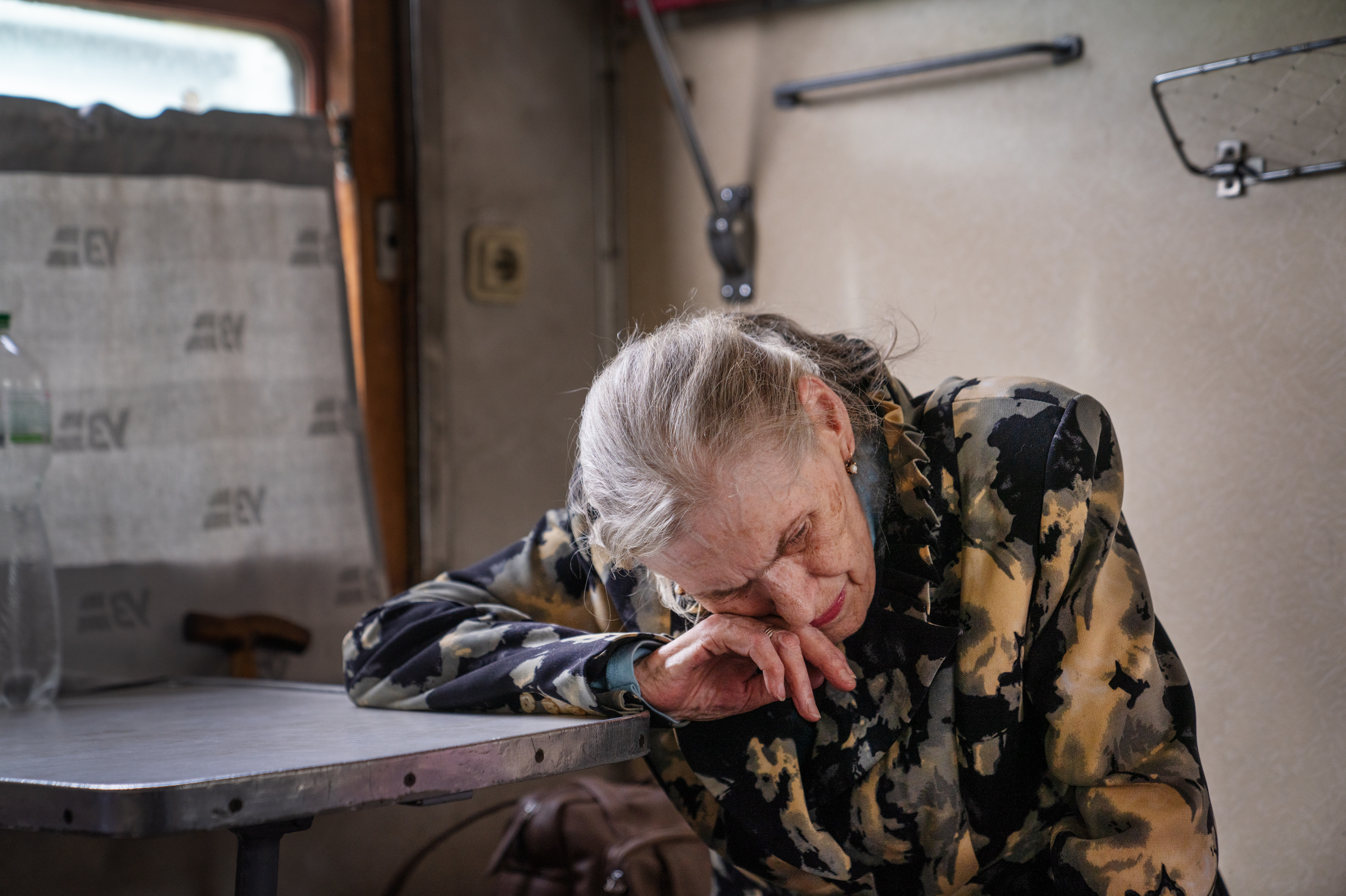 A Ukrainian rescue worker's memories are on pause as he evacuates people 6 Lyudmilla Nesterova leans on a table on the evacuation train. She realized she will likely never see Toretsk again.