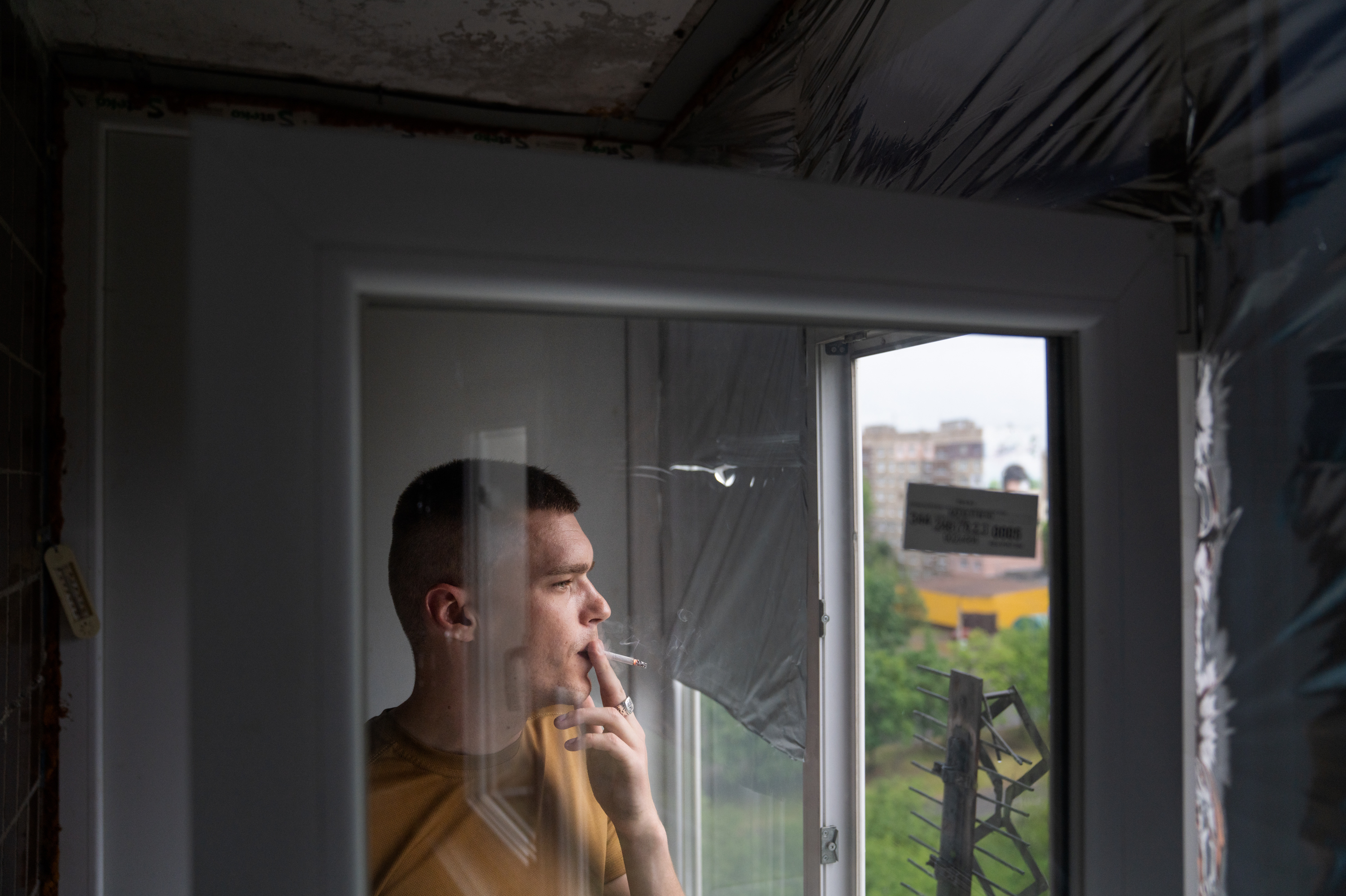 A Ukrainian rescue worker's memories are on pause as he evacuates people 5 Skoryk smokes a cigarette looking out the window of his apartment.
