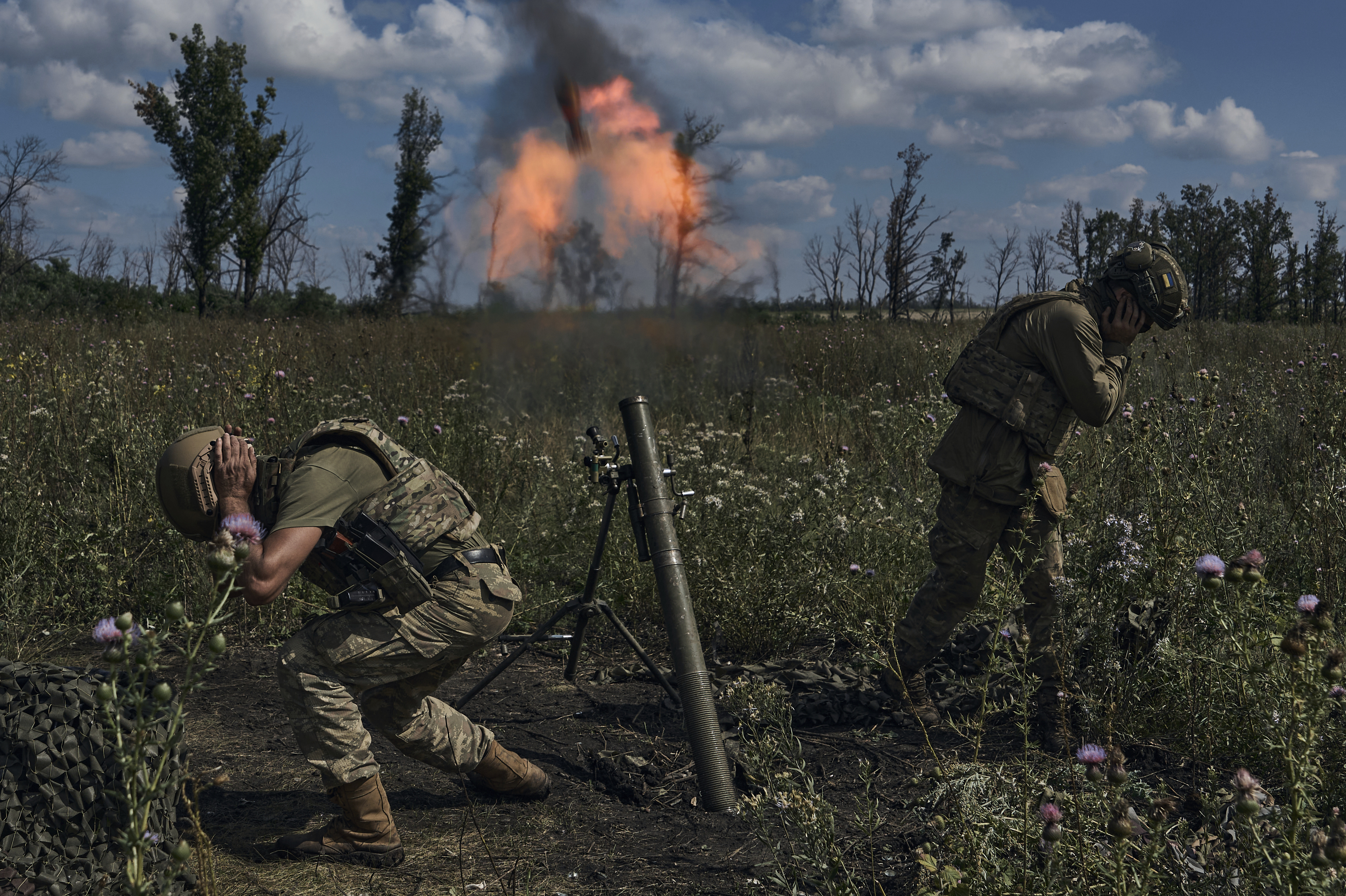 A Ukrainian rescue worker's memories are on pause as he evacuates people 2 Ukrainian soldiers fire a mortar toward Russian positions at the front line near Bakhmut, Ukraine, on Aug. 12.