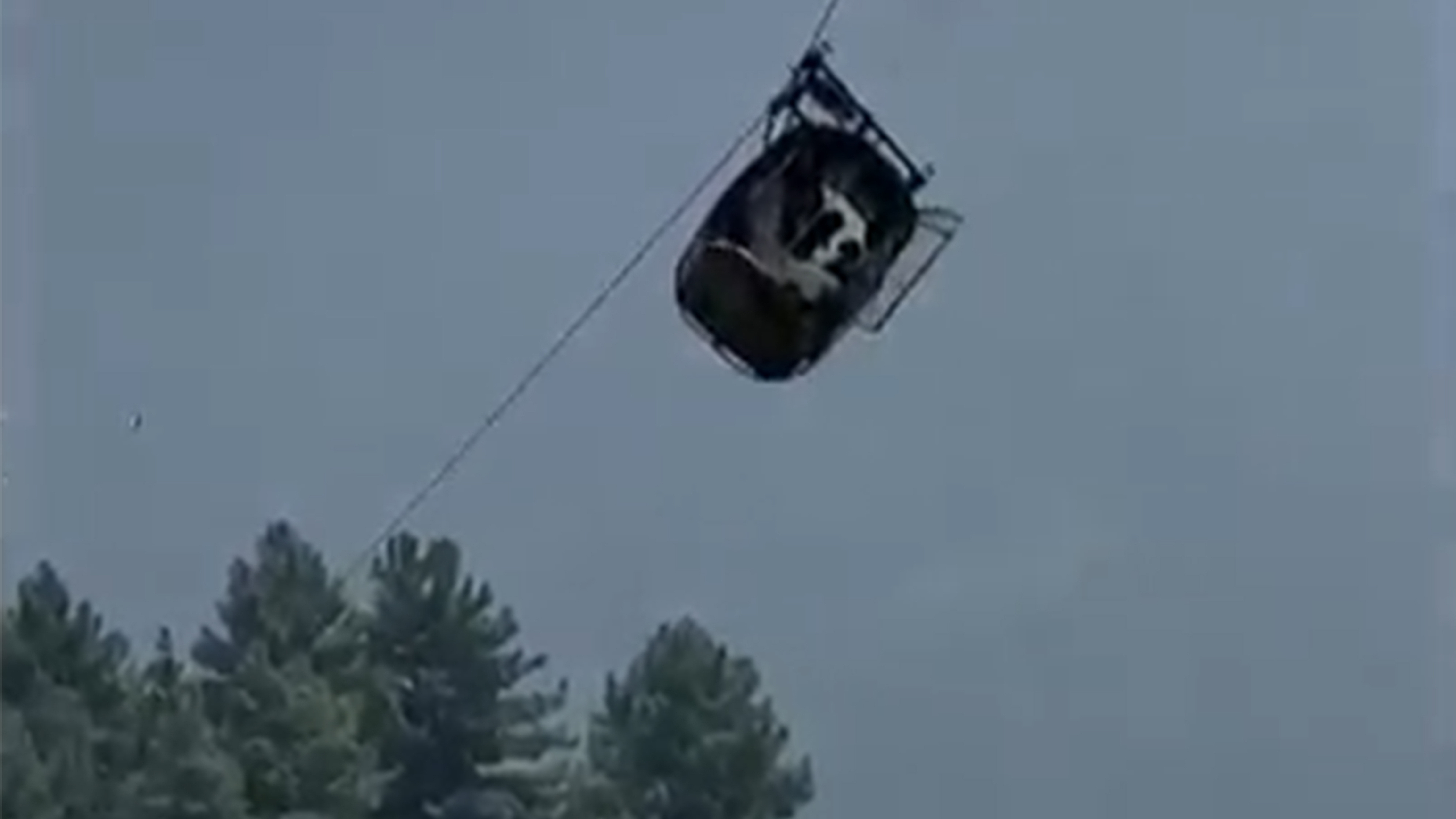 Pakistan rescuers try to free schoolkids trapped in a cable car hundreds of feet up