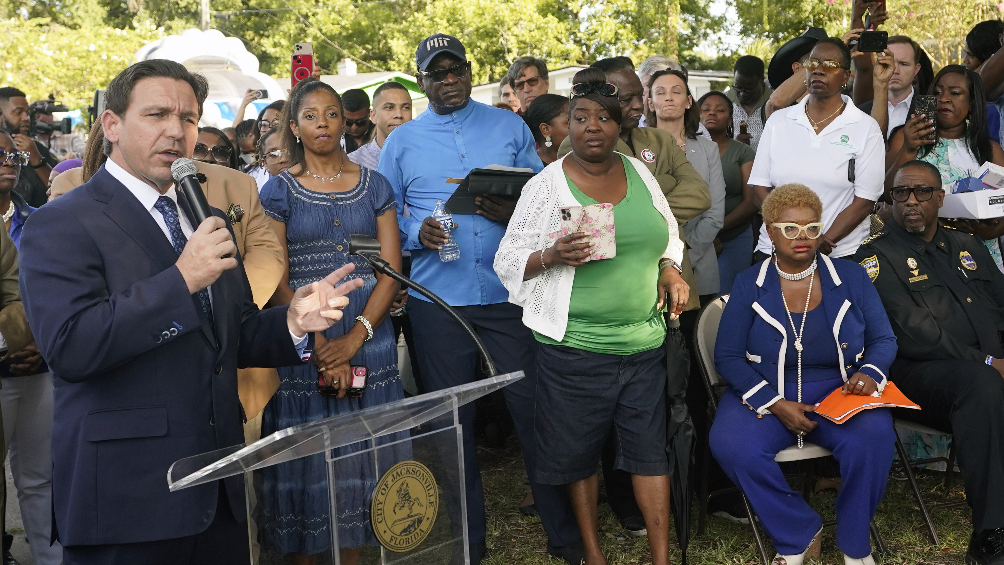 Florida Gov. Ron DeSantis, left, speaks at a prayer vigil on Sunday for the victims of a mass shooting that took place Saturday in Jacksonville, Fla.