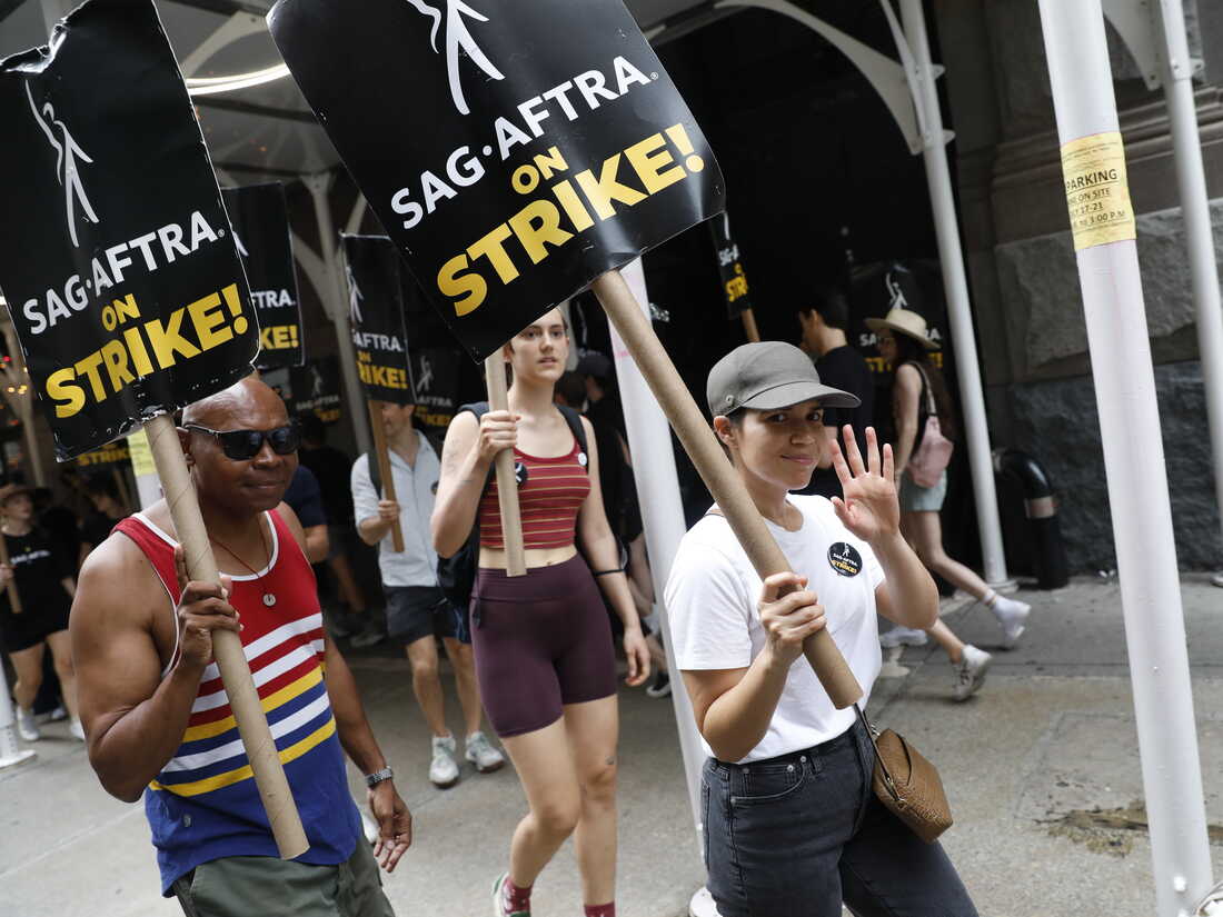 Members of the public interact with a screen featuring the artist News  Photo - Getty Images