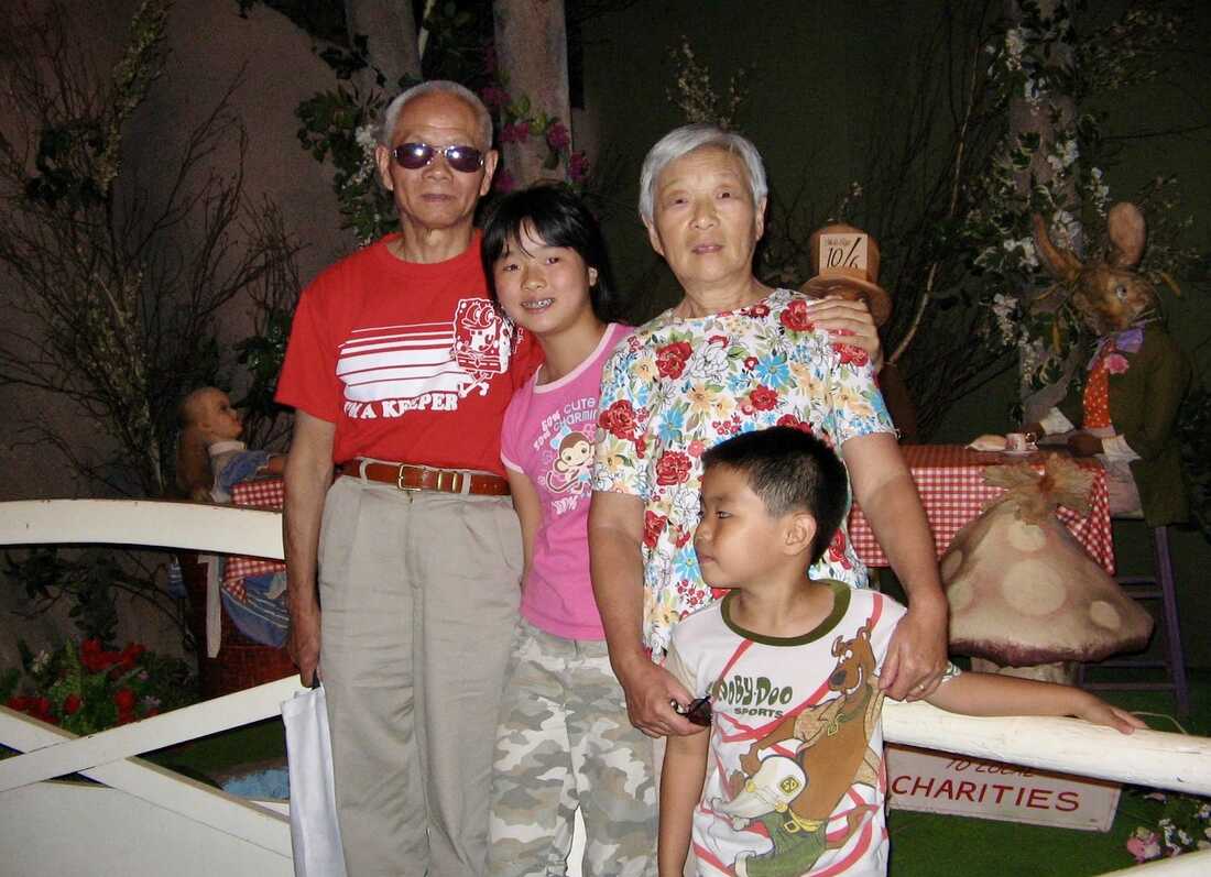 Old grandma and grandpa stand together arm in arm. Couple with big