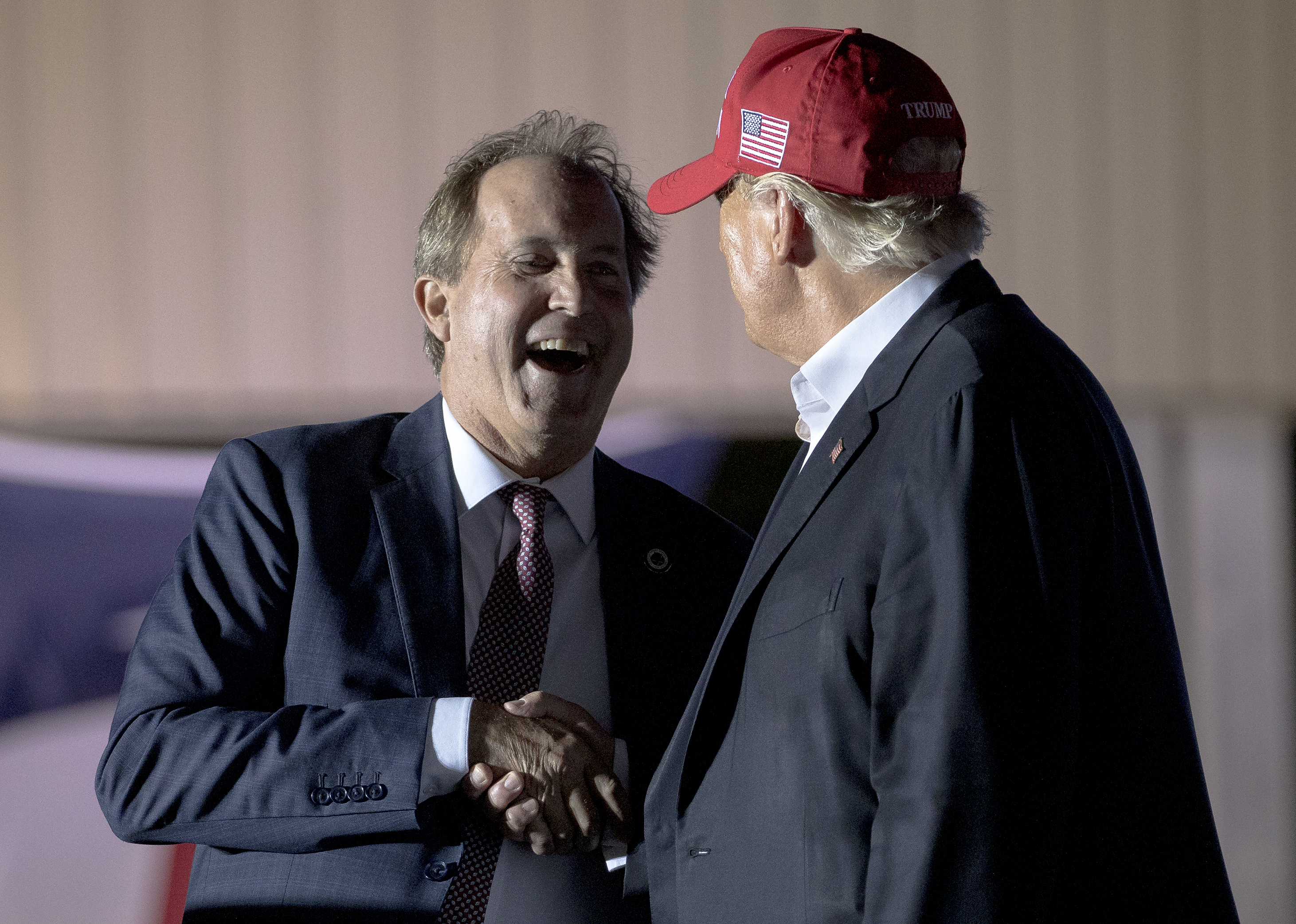 Former President Donald Trump (right) shakes hands with Texas Attorney General Ken Paxton at an October 2022 rally in Robstown, Texas.
