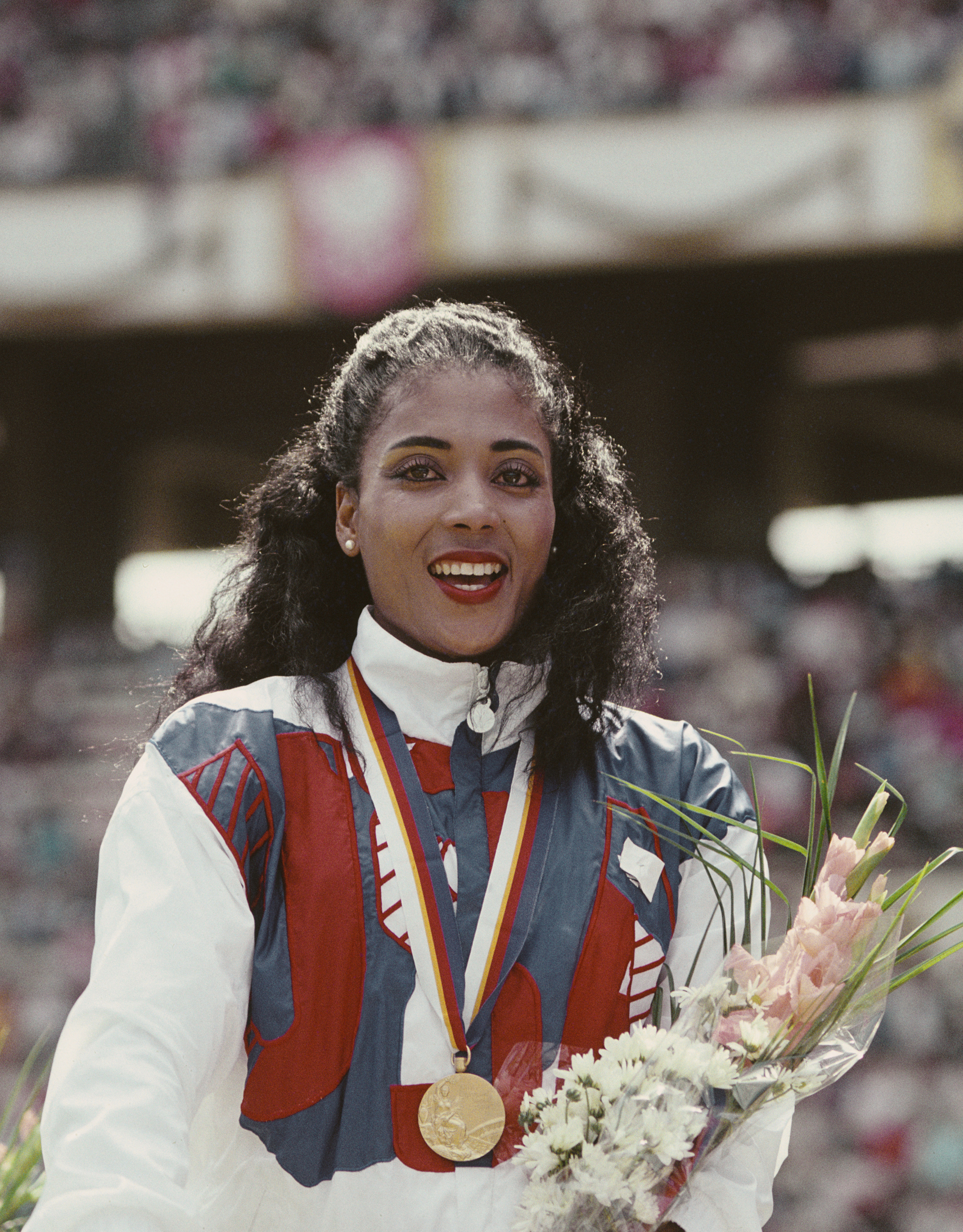 Florence Griffith-Joyner celebrates with her gold medal after winning the Women's 100 meters final event during the 1988 Summer Olympic Games in Seoul, South Korea. (Allsport/Getty Images)
