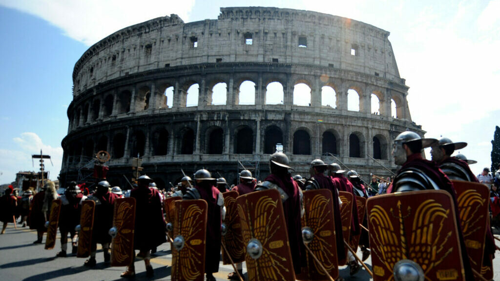 People dressed as soldiers of the ancient Rome march in front of the Coliseum during a parade to celebrate the anniversary of the legendary foundation of the city of Rome. (AFP via Getty Images)