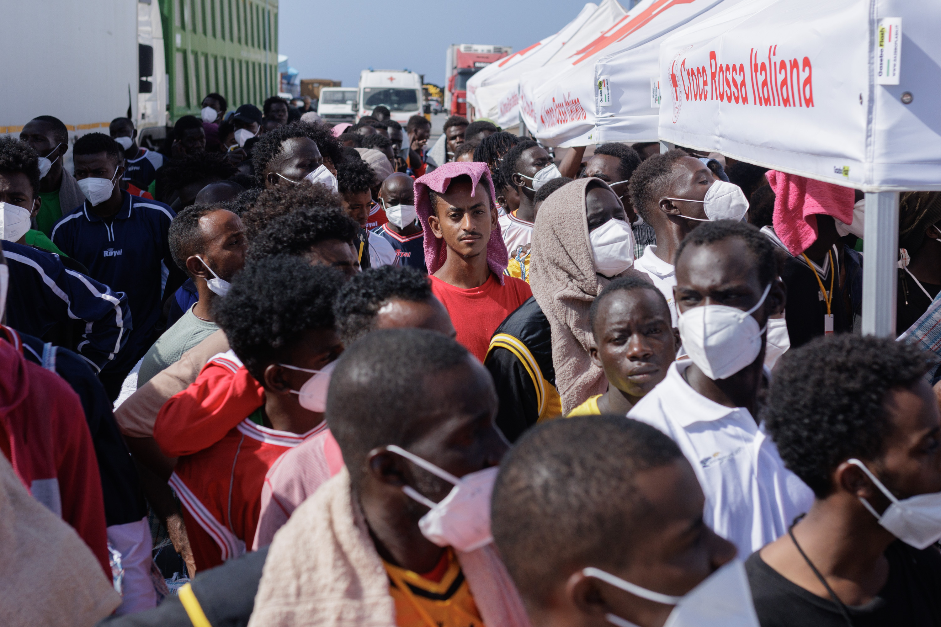 Migrants in Lampedusa's Porto Vecchio wait to be transferred by ferry to Porto Empedocle, from where they will be sent to reception centers across the country, Sept. 22. Most of them arrived in the previous week, a period when Lampedusa declared a state of emergency due to an influx of about 7,000 migrants in a few days. (Valerio Muscella for NPR)