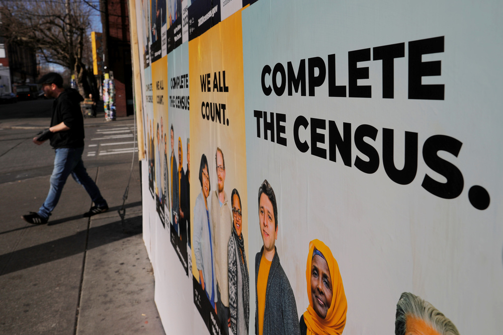 Signs advertising the U.S. census cover a closed and boarded-up business in Seattle in 2020. (Reuters)