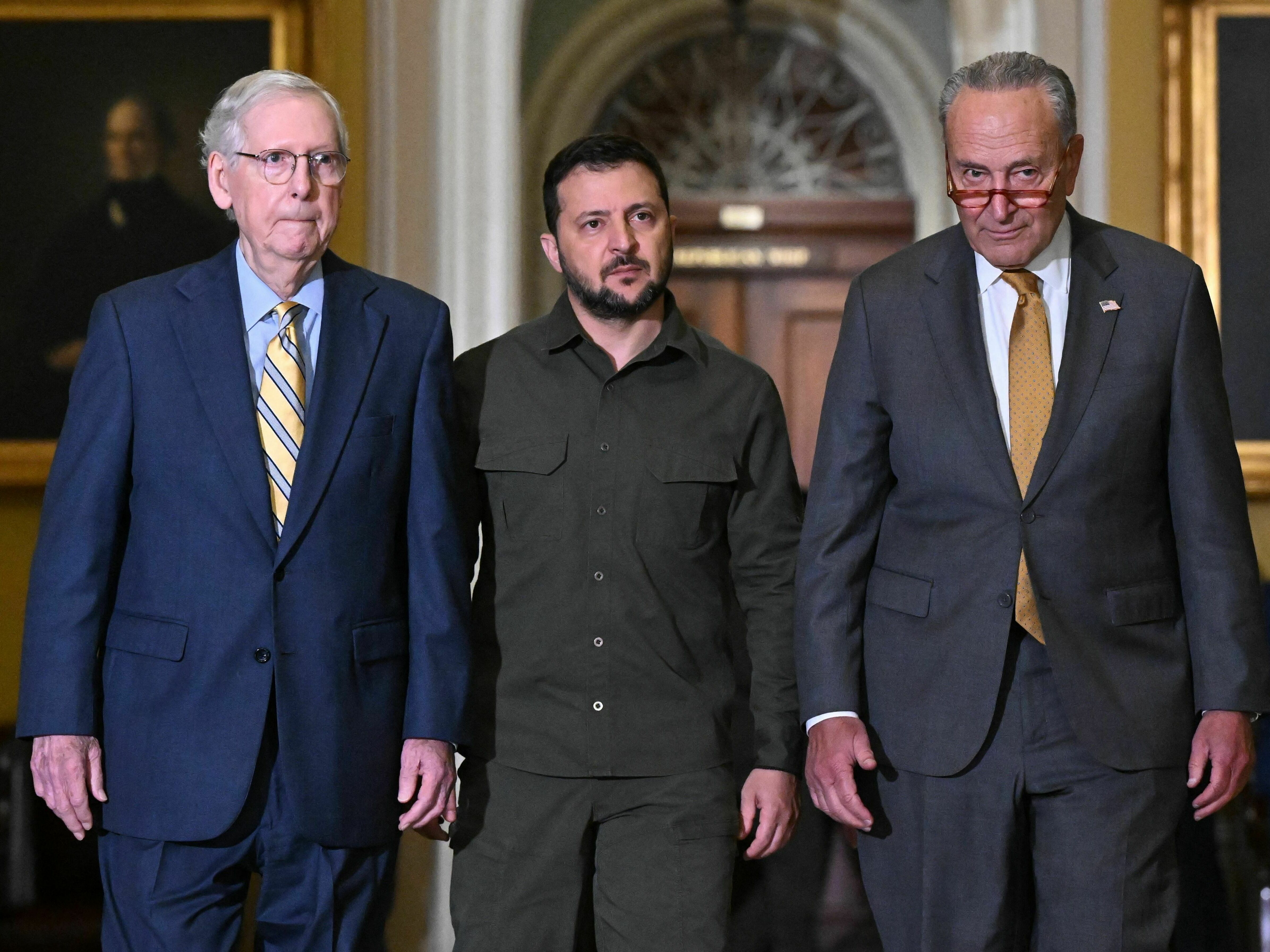 Ukrainian President Volodymyr Zelensky (C) walks with Senate Majority Leader Chuck Schumer (R) and Senate Minority Leader Mitch McConnell (L) during a trip to Washington last month.