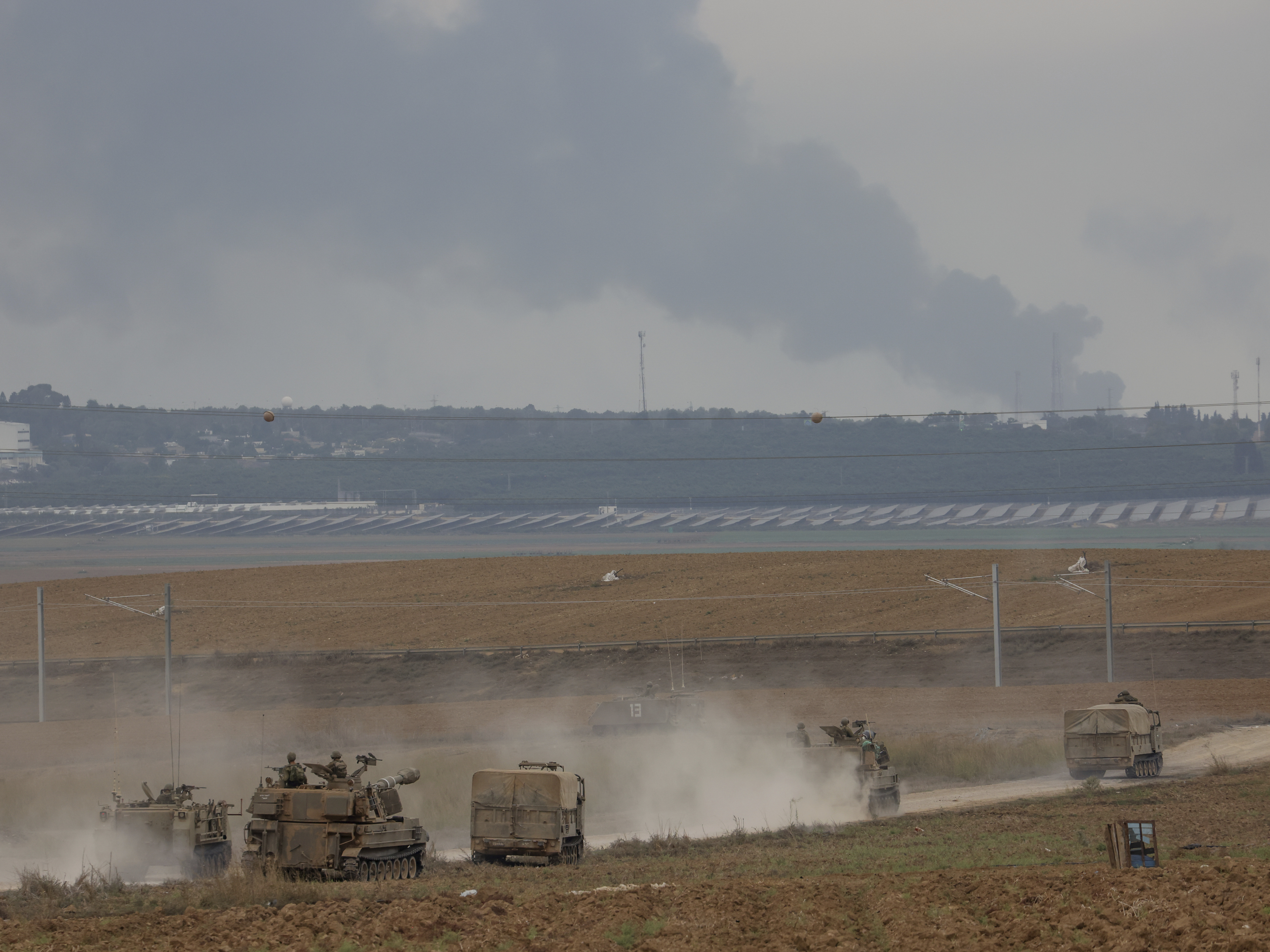 Israeli army vehicles move near the Israeli Gaza border, southern Israel, Oct. 9, 2023.