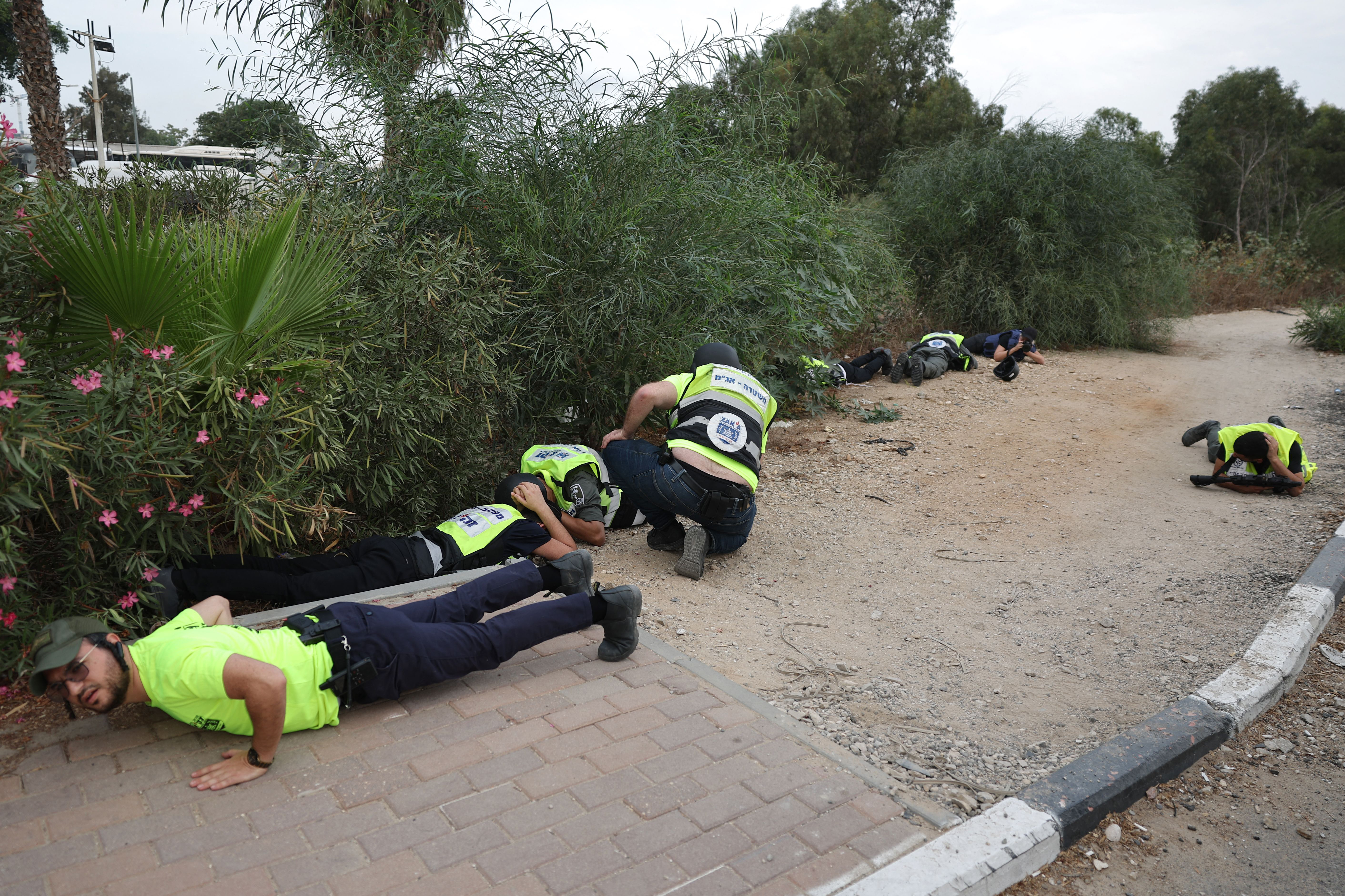 Mon., Oct. 9: Israeli emergency responders take cover during a rocket attack near the border with Gaza.