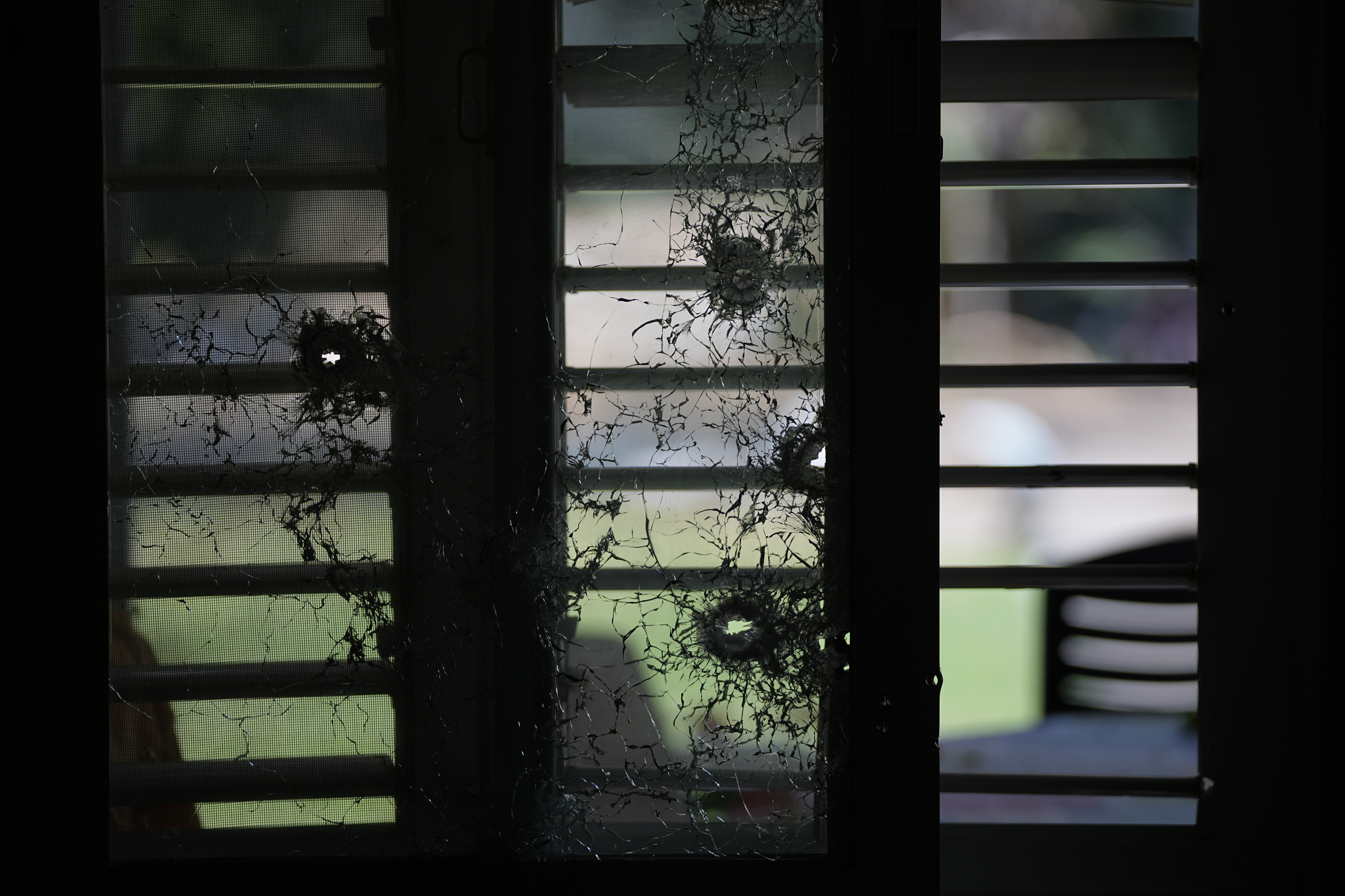 Tues., Oct. 10: A window pierced by bullets is seen from inside a house in kibbutz Kfar Azza.