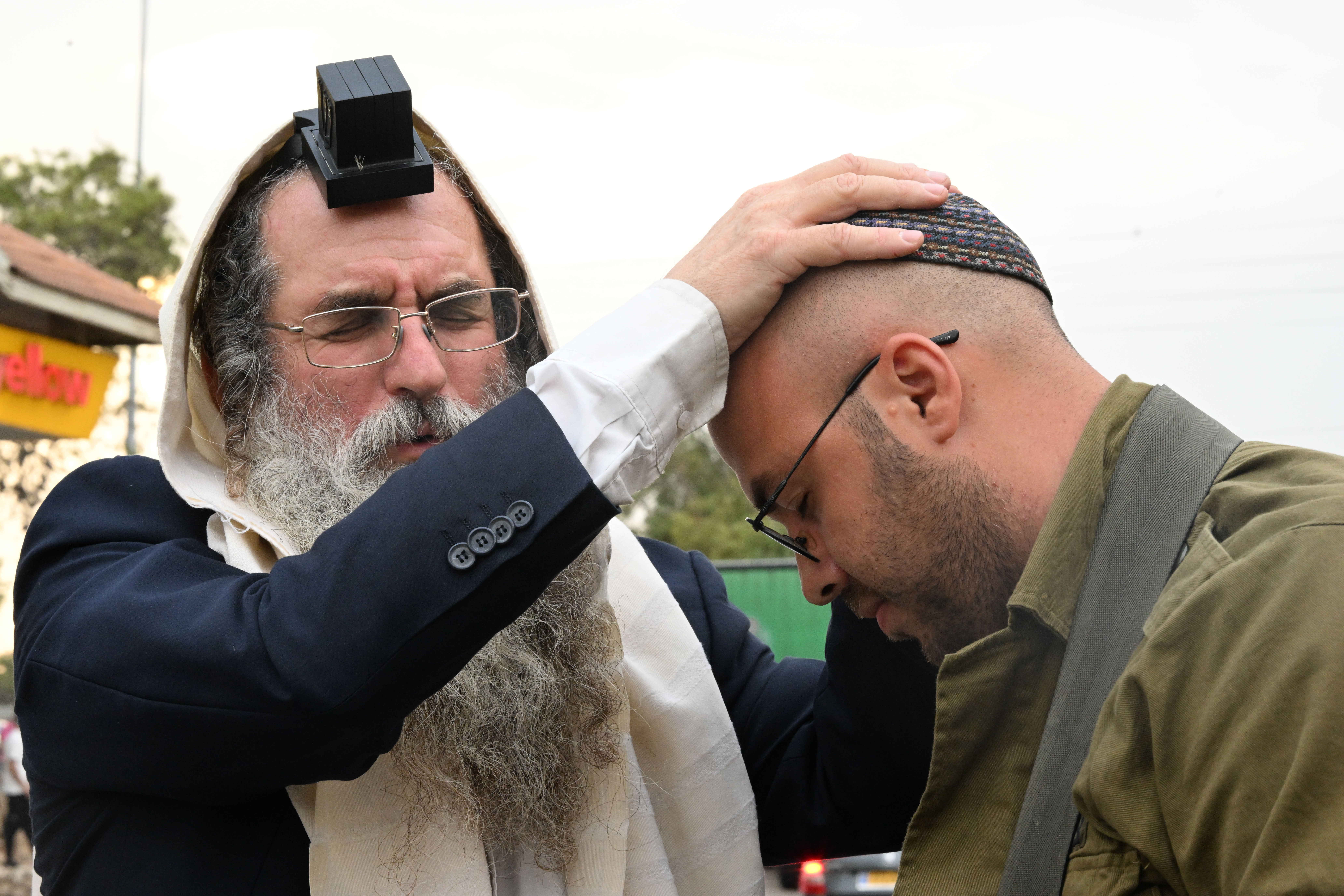 At a rest stop near Hamas attack sites, Israelis rush to help families and soldiers 4 A religious Jewish man offers soldiers blessings and prayers.