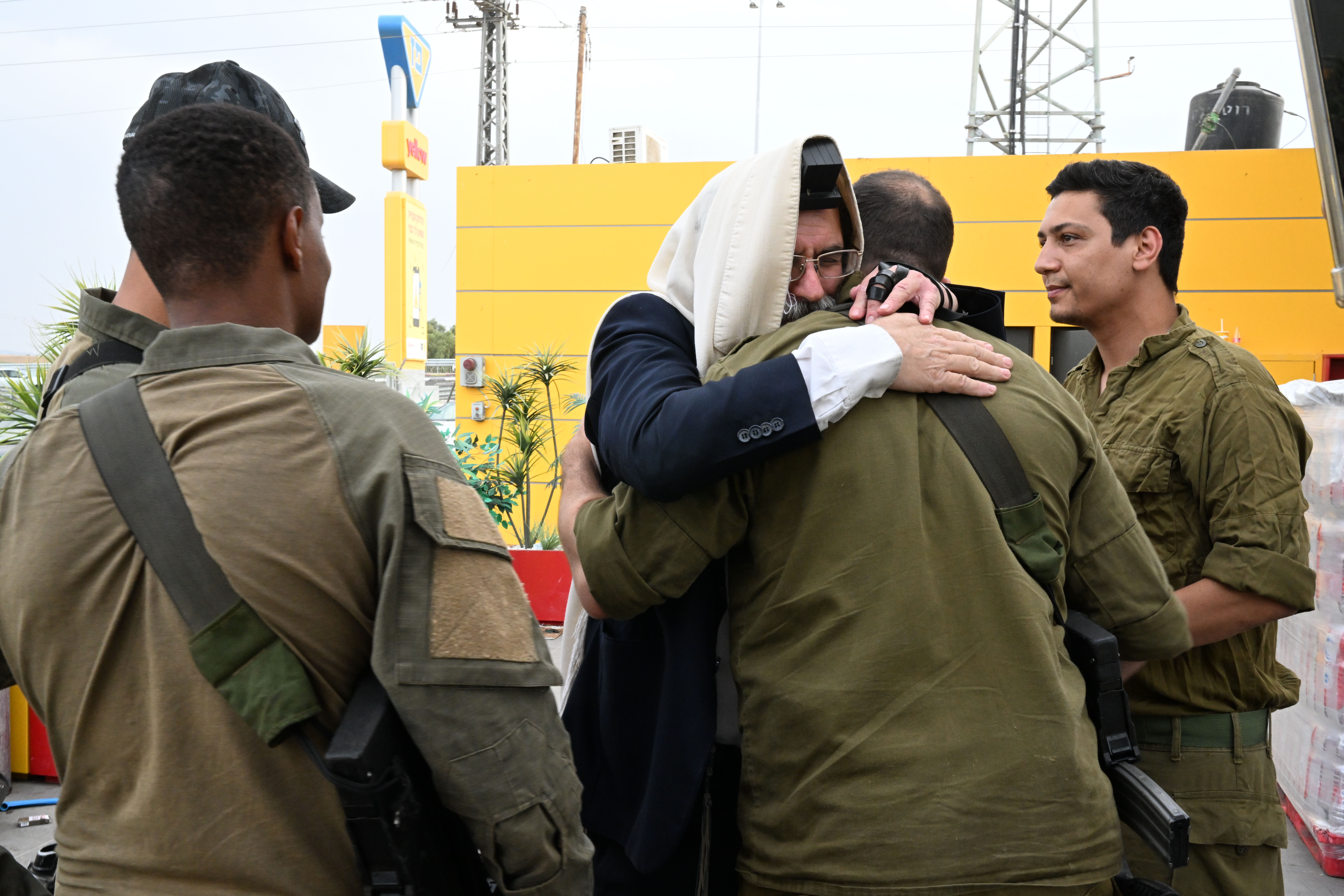 At a rest stop near Hamas attack sites, Israelis rush to help families and soldiers 5 One by one, a religious Jewish man gives soldiers a long hug.