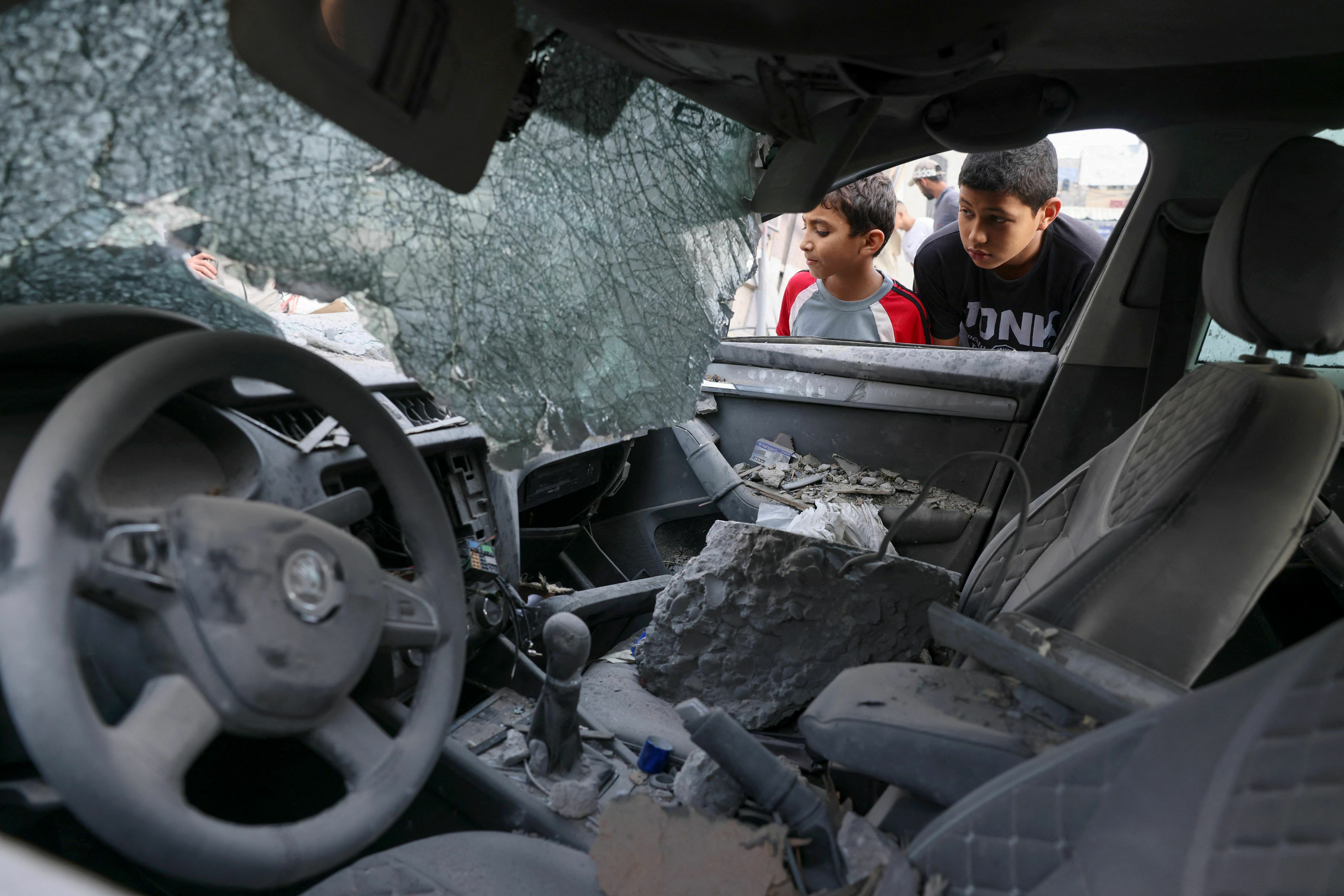 Tues., Oct. 10: Palestinian children inspect a damaged car following Israeli shelling in the city center of Khan Yunis in the southern Gaza Strip.