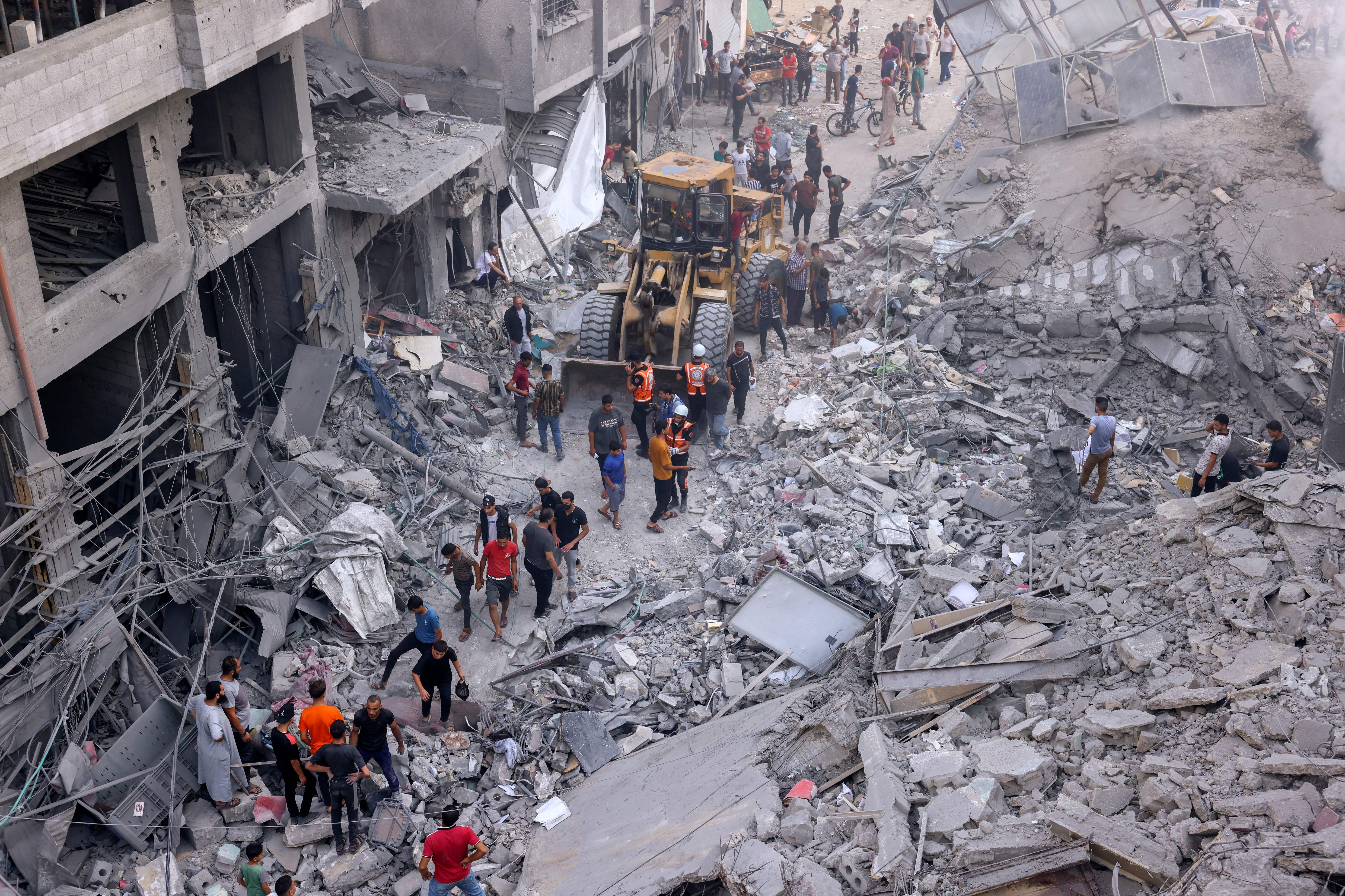Tues., Oct. 10: Palestinian civilians and rescuers help clear the rubble in the heavily bombarded city center of Khan Yunis in the southern Gaza Strip following overnight Israeli shelling.