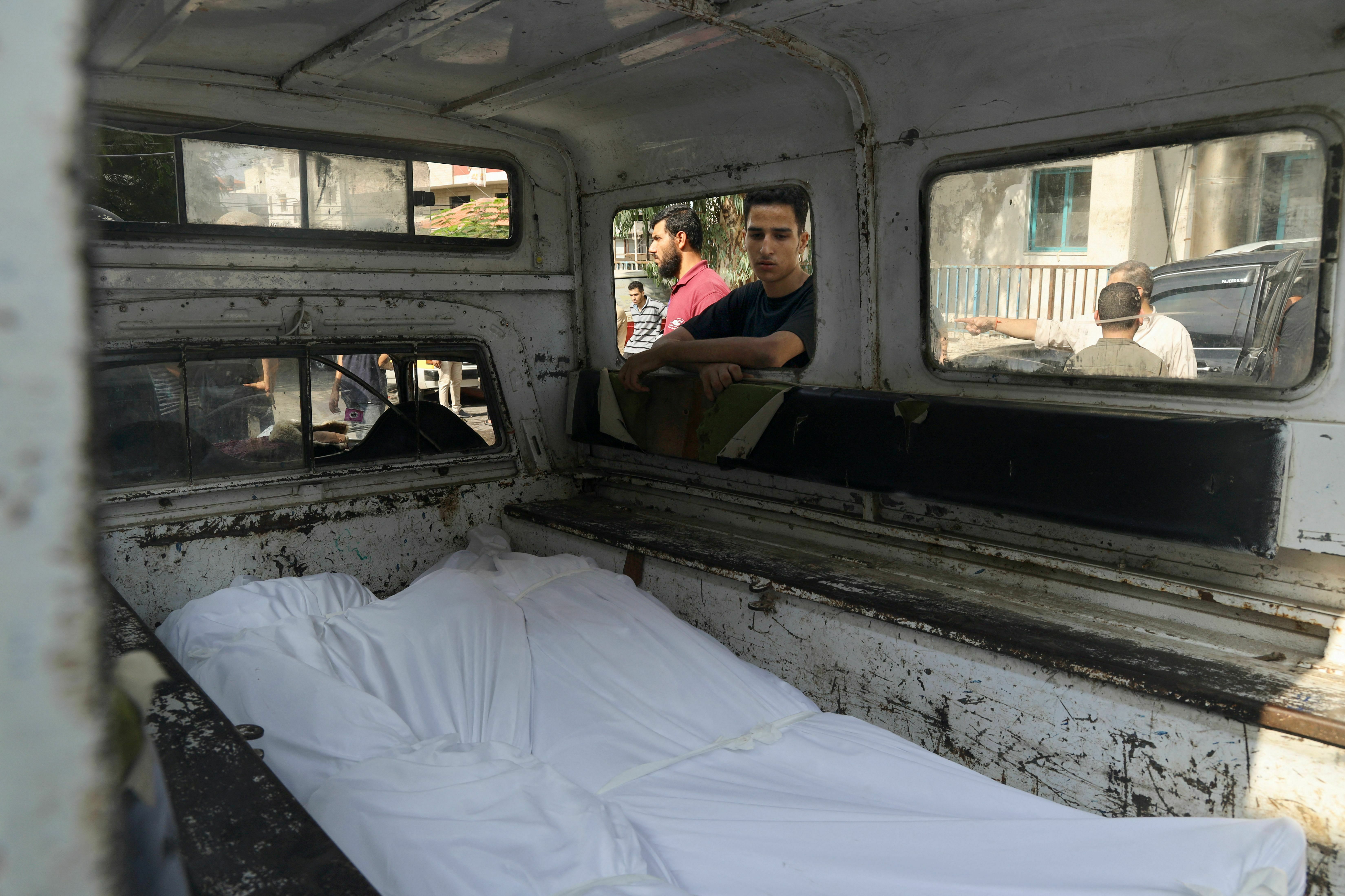 Tues., Oct. 10: A young man looks at bodies of Palestinians killed in Israeli shelling during a mass funeral in Gaza City.