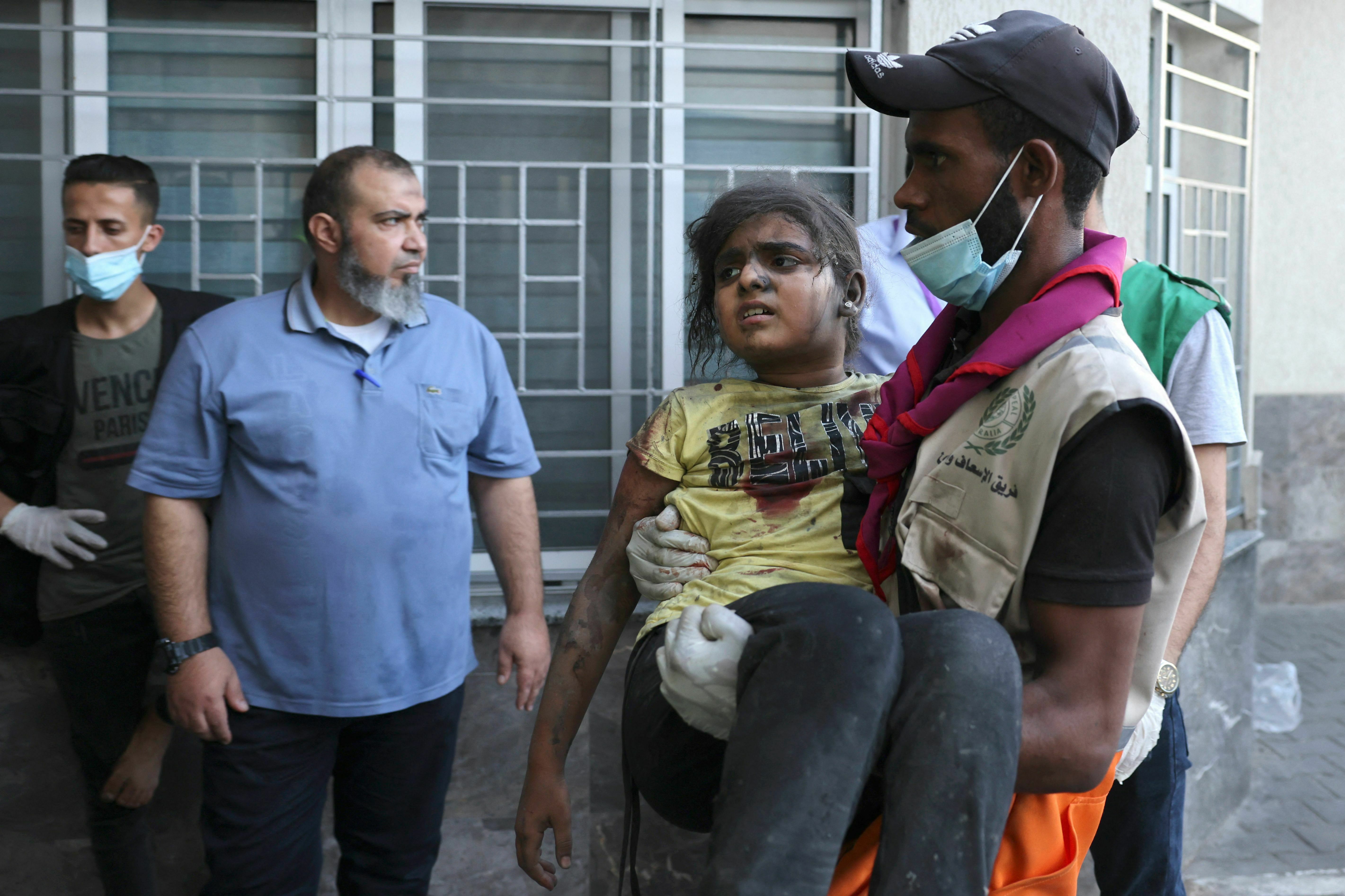 Tues., Oct. 10: A man carries a wounded child into at al-Shifa hospital following Israeli strikes in Gaza City.