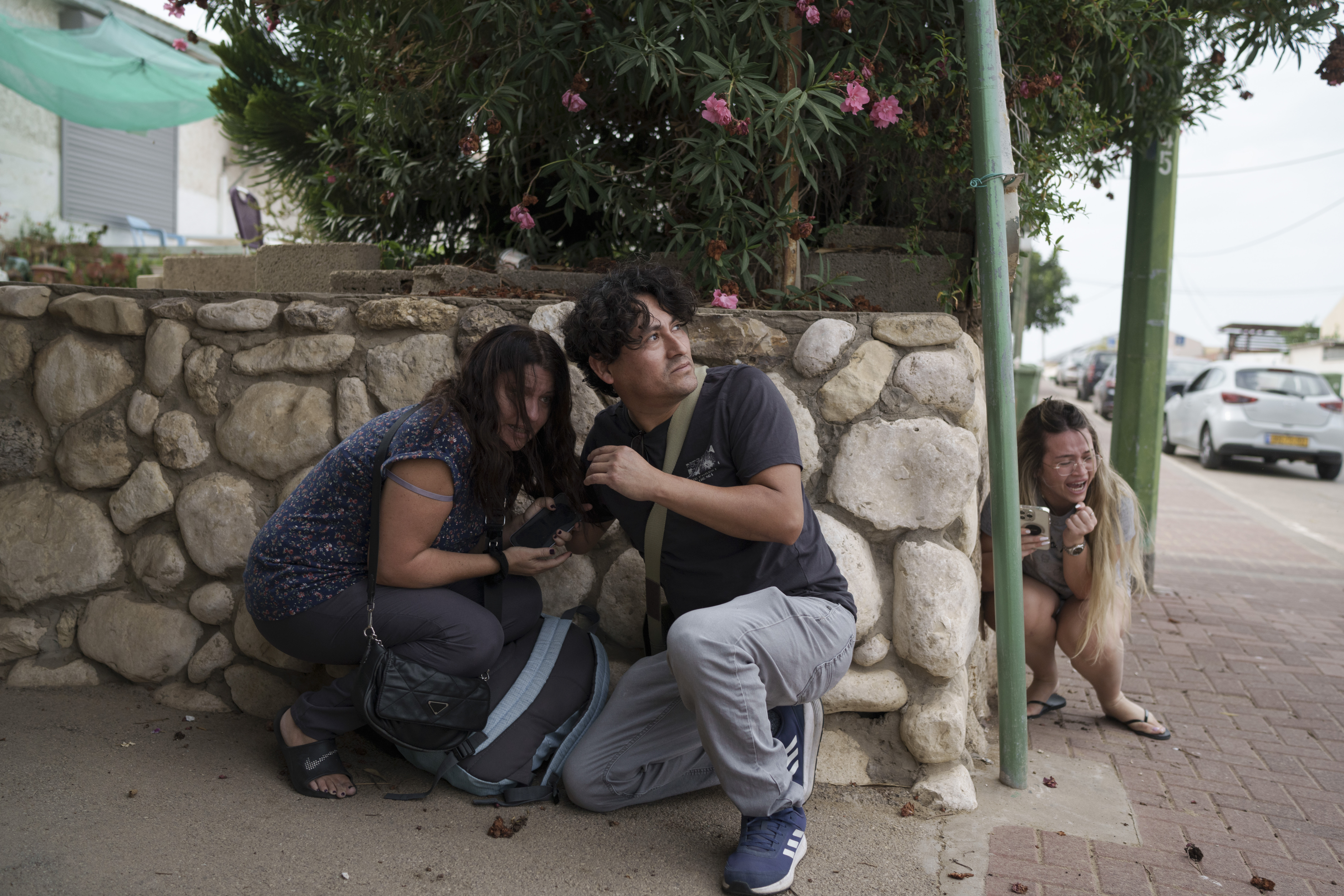 Wed., Oct. 11: Israelis take cover from the incoming rocket fire from the Gaza Strip in Ashkelon, southern Israel.