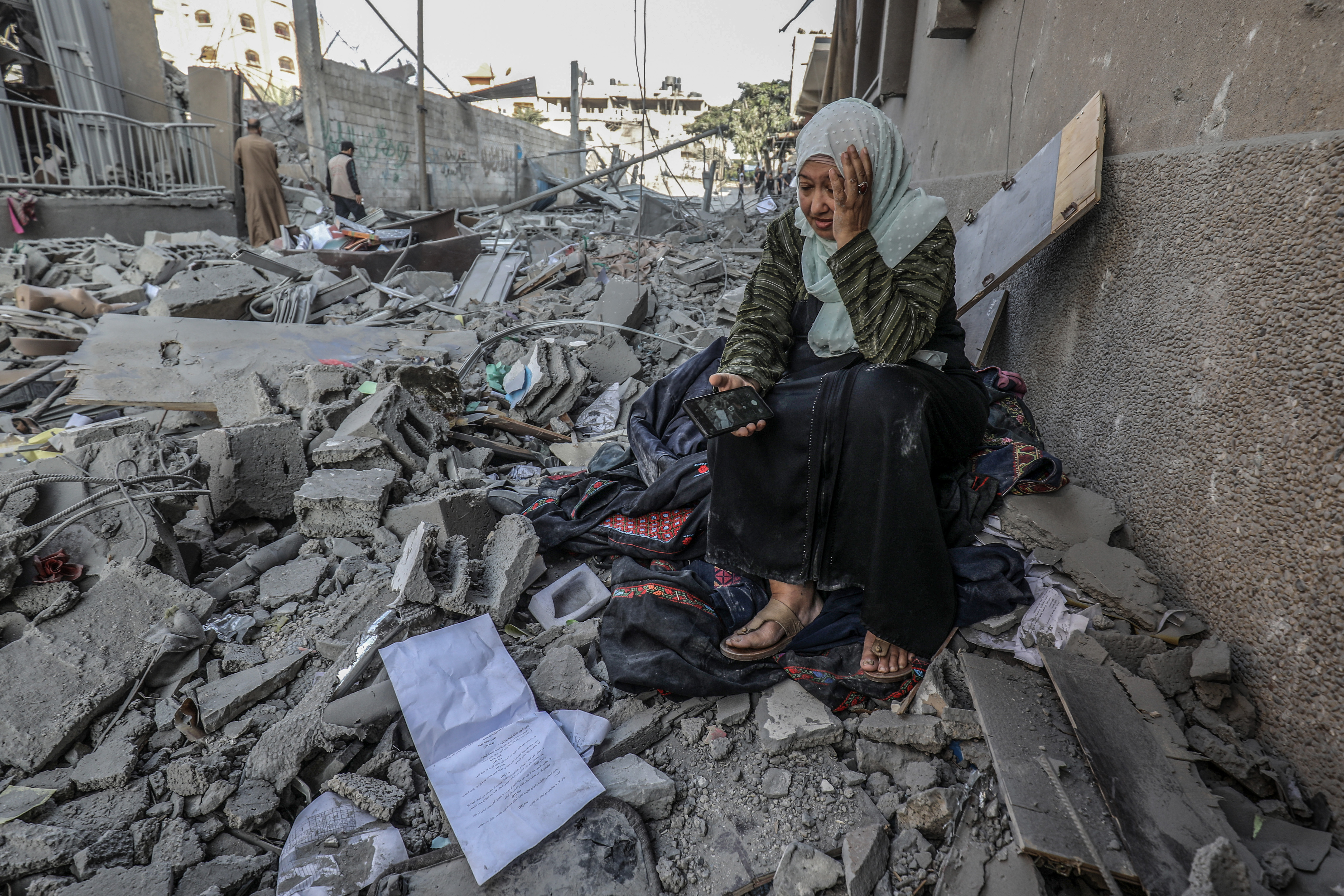 Wed., Oct. 11: A Palestinian woman sits on the ruins of her destroyed home following Israeli air strikes in Gaza City.