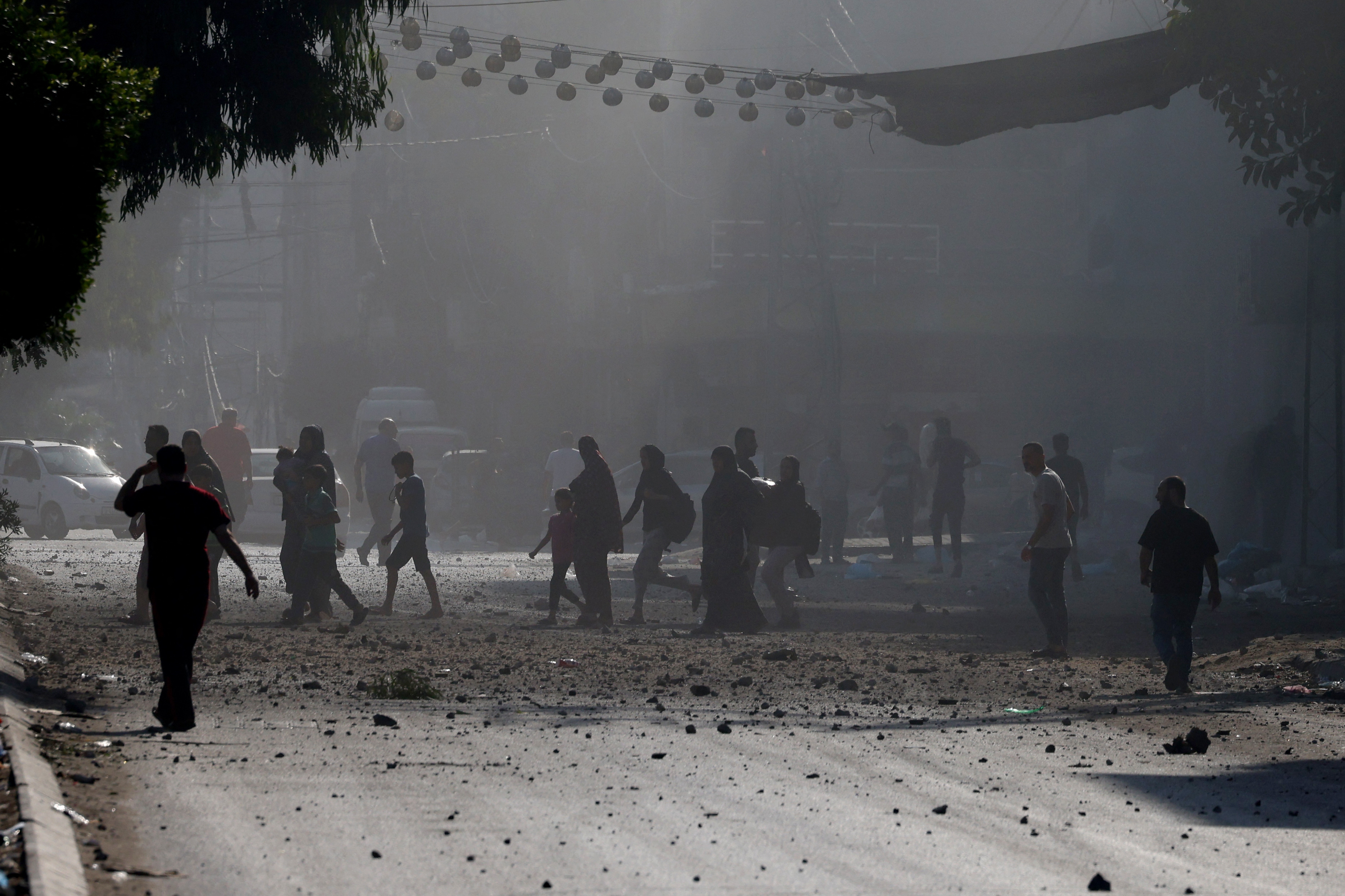 Wed., Oct. 11: Palestinians evacuate a neighborhood in Gaza City during Israeli airstrikes.