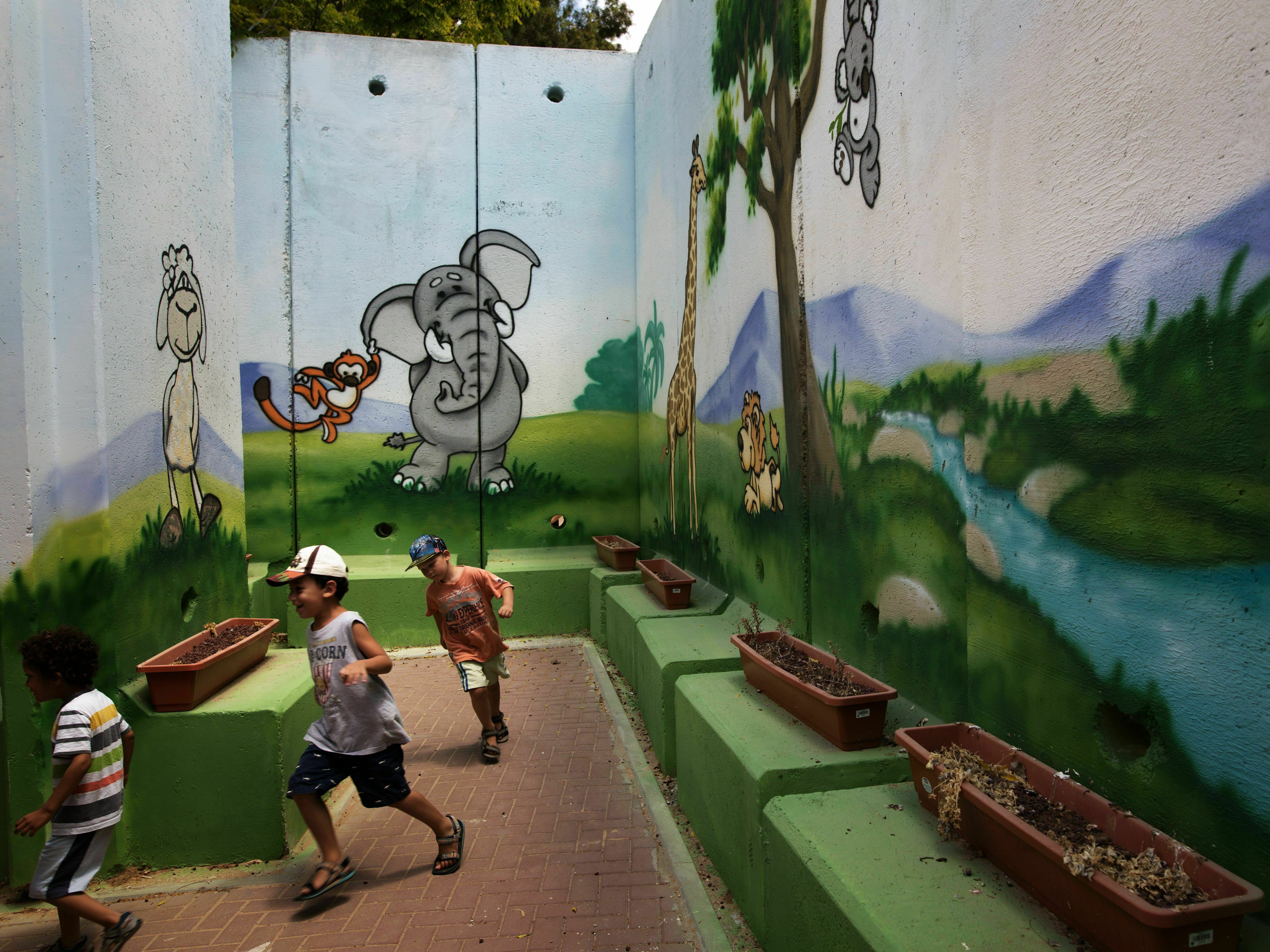 Children play at a kindergarten surrounded by decorated concrete blast walls designed to protect from rocket and mortar fire in 2015 in the southern Israeli Kibbutz of Nahal Oz near the border with the Gaza Strip. (AFP file photo via Getty Images)