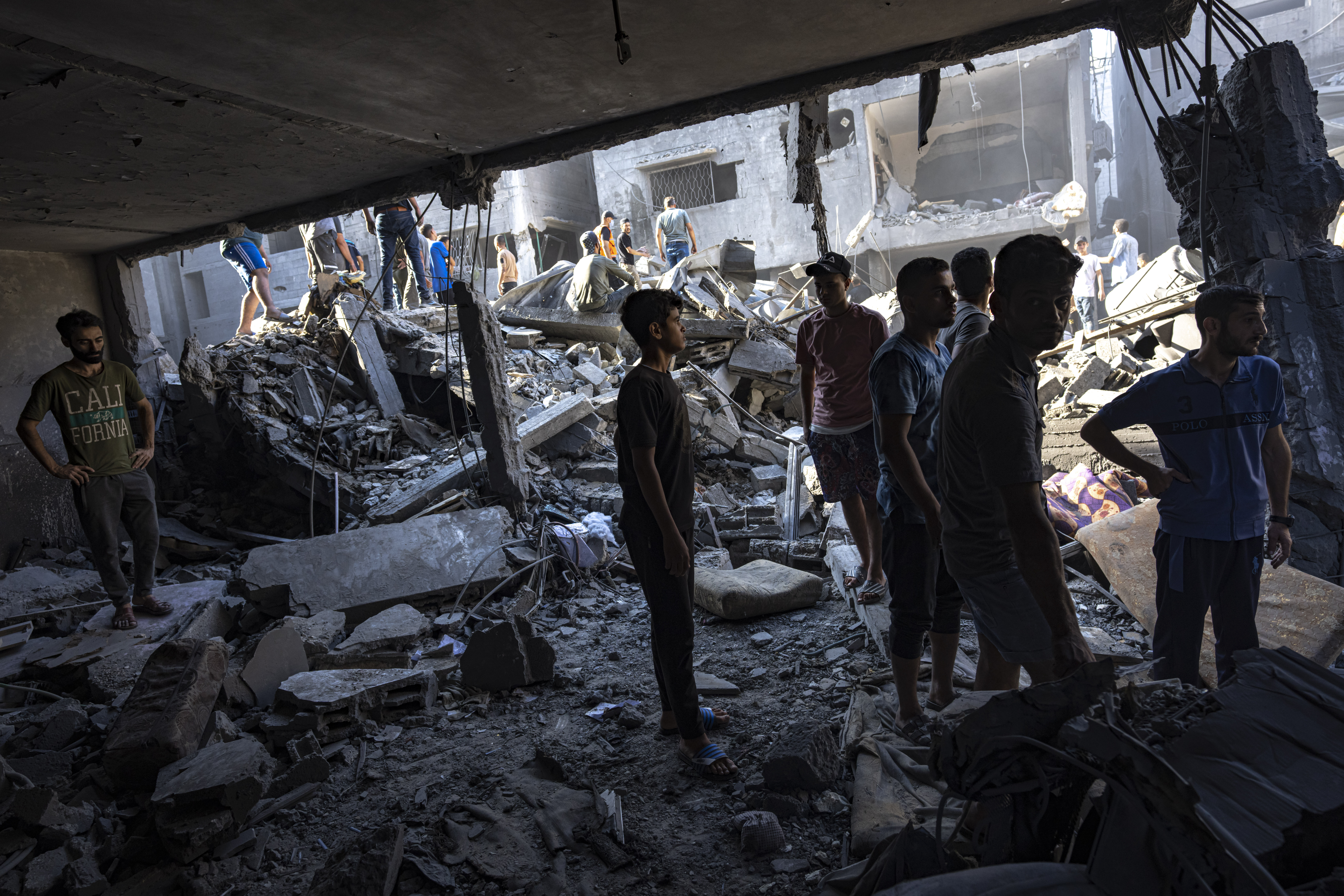 Thu., Oct. 12: Palestinians search for bodies and survivors in the rubble of a residential building leveled in an Israeli airstrike, Al Shati Refugee Camp.