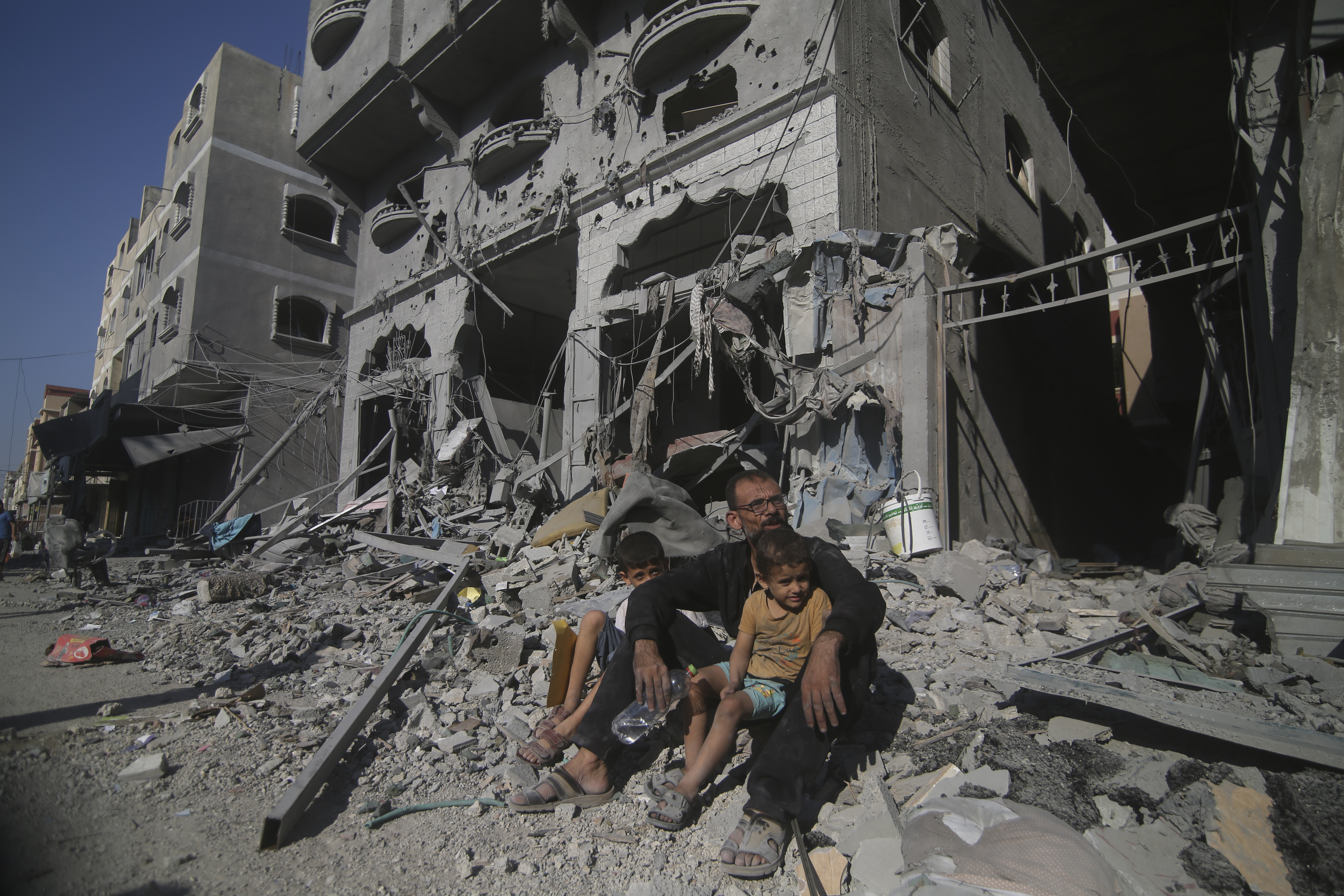 Thu., Oct. 12: Palestinians sit outside their house following Israeli airstrikes in Rafah refugee camp, southern Gaza Strip.