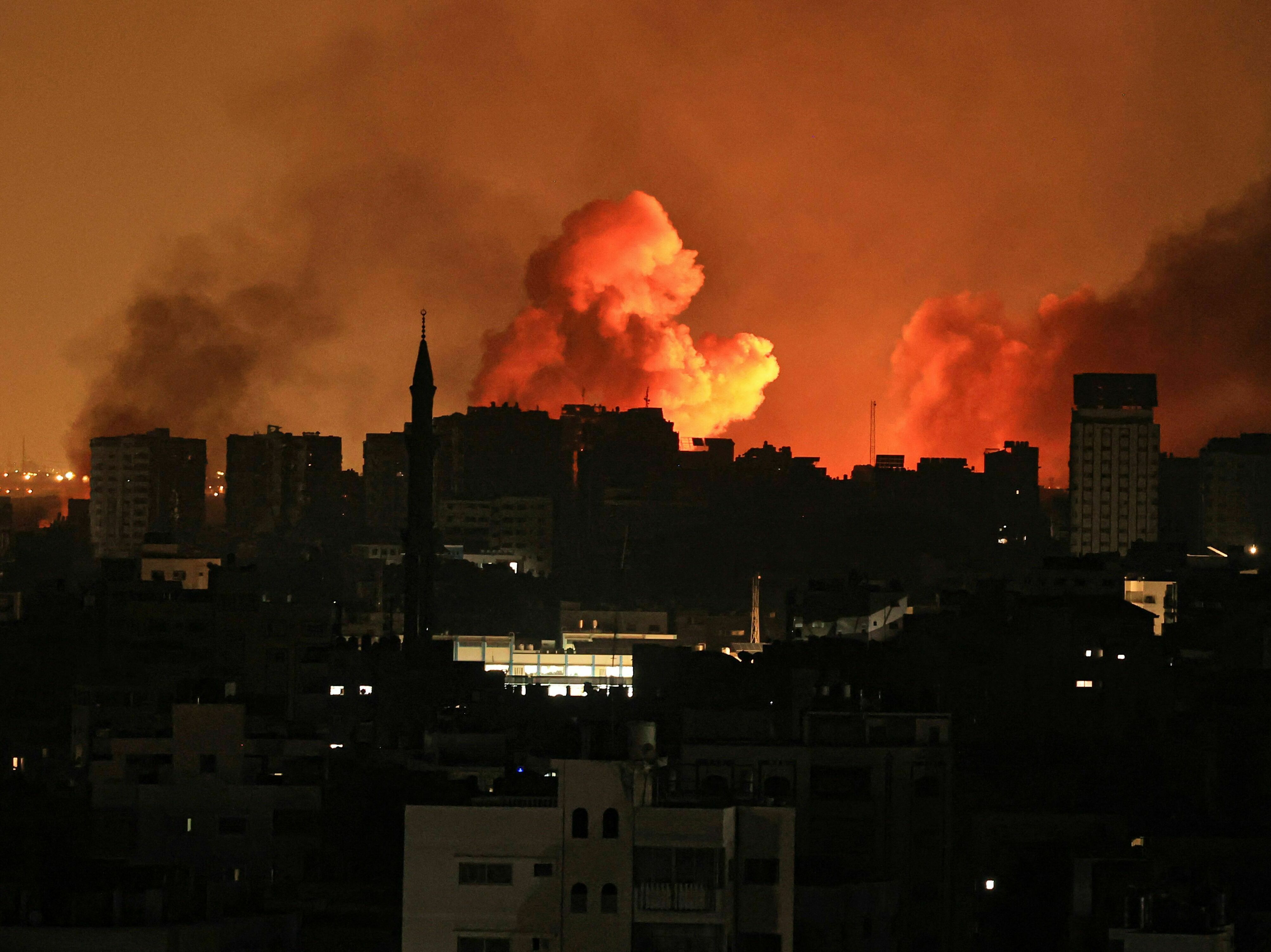 A ball of fire erupts in Gaza City after an Israeli air strike on October 12, 2023 (AFP)
