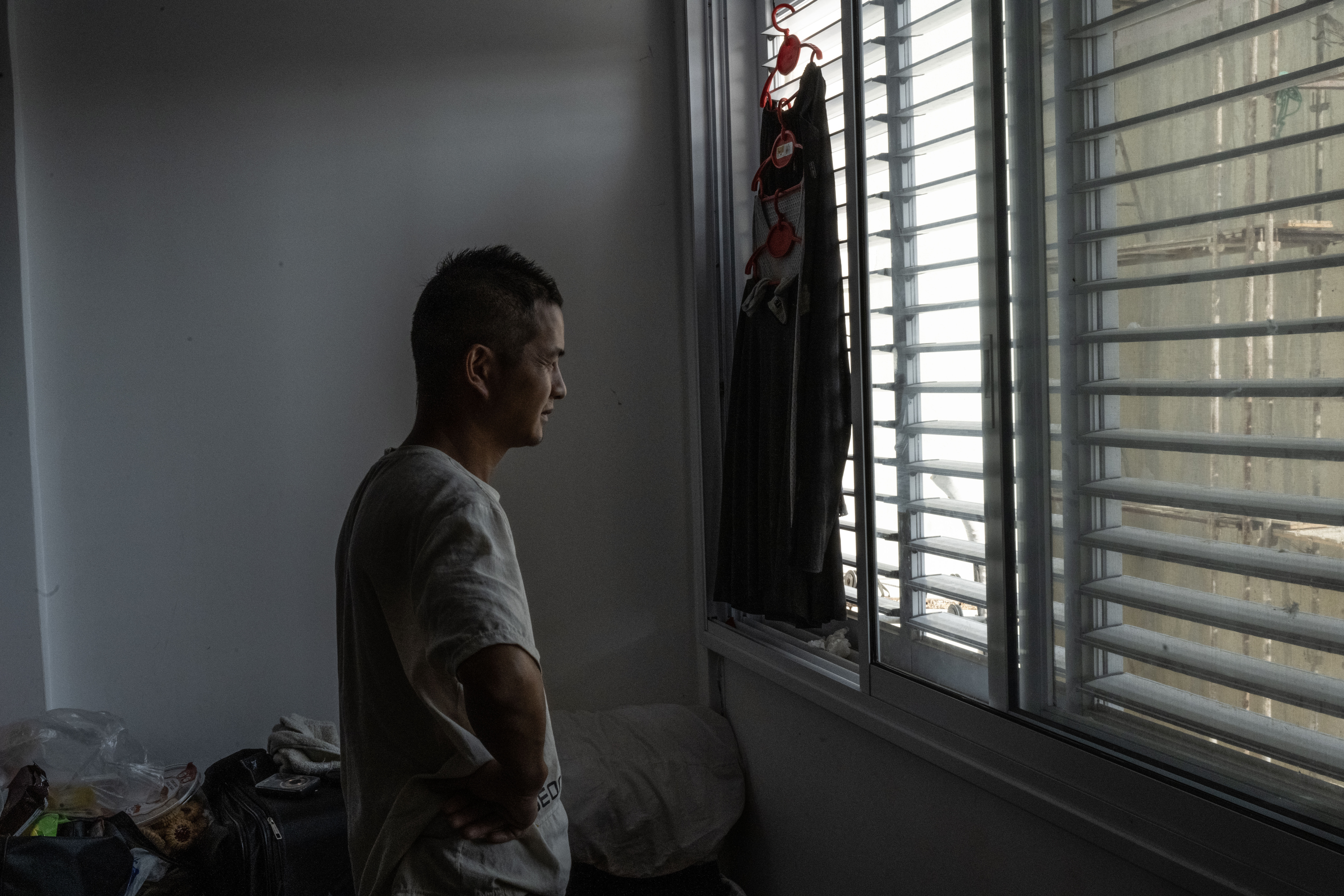 Left behind, in an assaulted Israeli town 3 A construction worker from China stands in a small apartment in Sderot.