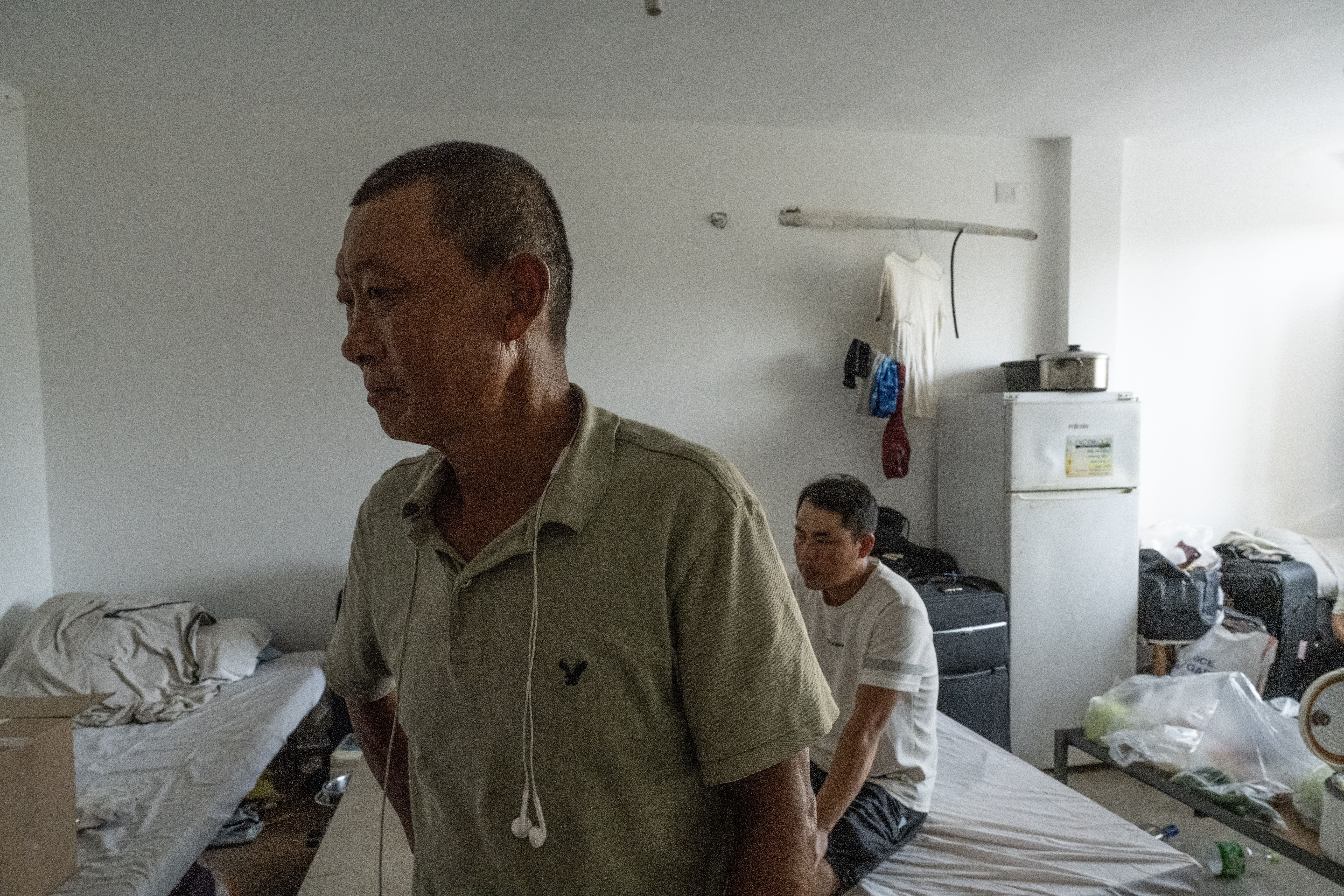 Left behind, in an assaulted Israeli town 2 Jiang Hua (left) is one of eight guest workers from China in a crowded apartment room in Sderot, Israel.