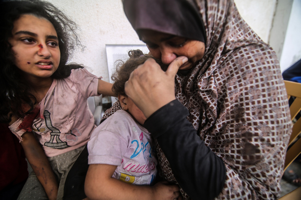 People injured from Israeli air strikes on Oct. 12 wait outside a hospital to be treated. The sheer volume of medical need is overwhelming the small and exhausted number of staff at Gaza's medical facilities, says Dr. Mohammad Mattar, head of the radiology department at Al Shifa Hospital, the Gaza Strip's largest medical complex. (Anadolu via Getty Images)