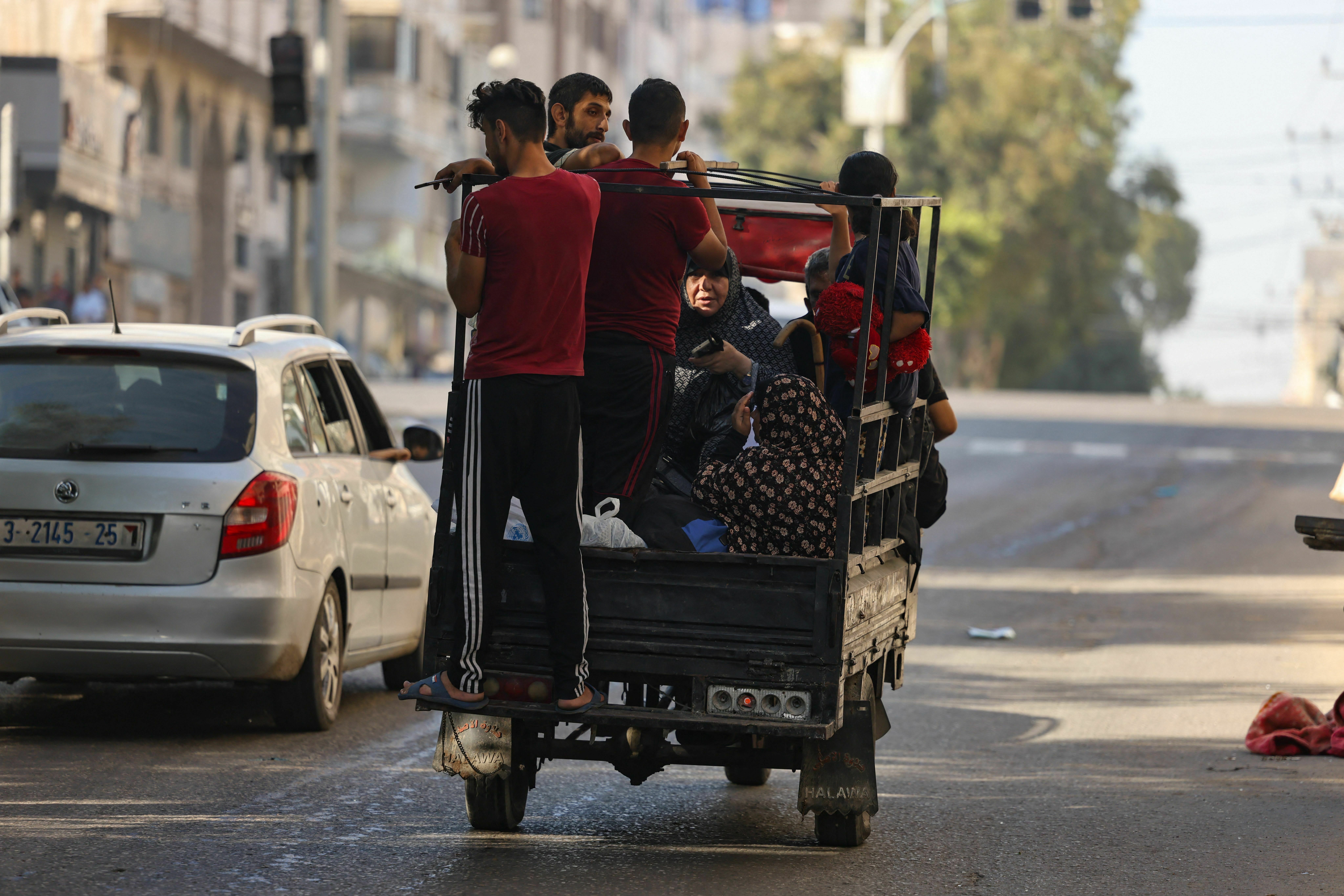 Fri., Oct. 13: Palestinians carrying their belongings flee to safer areas in Gaza City after Israeli air strikes,.