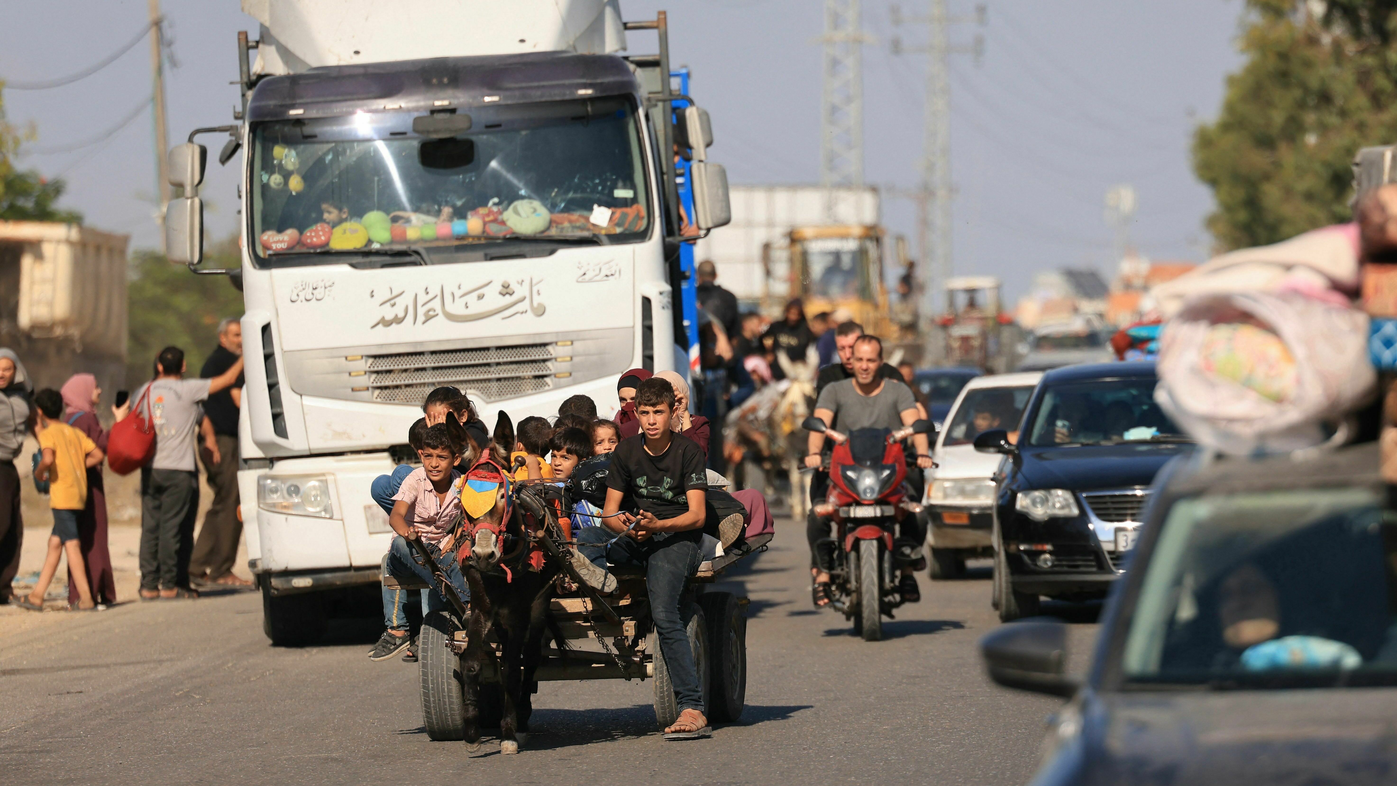 Palestinians in Gaza City — riding donkeys, driving cars and walking — flee northern Gaza on Friday after the Israeli military's warning to leave their homes and move south before an expected ground offensive. (AFP via Getty Images)