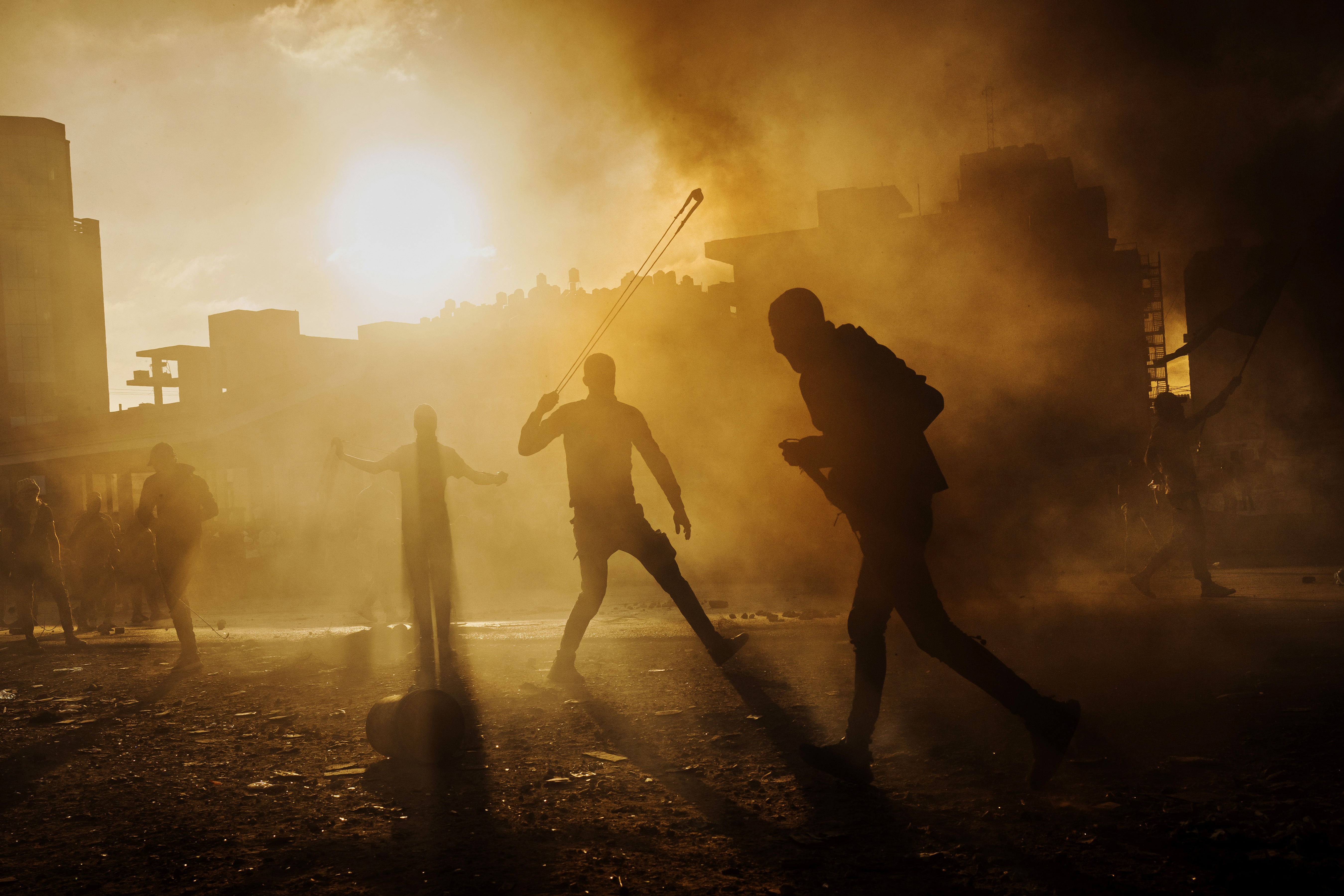 Fri., Oct. 13: A Palestinian man slings a rock at Israeli forces as local Palestinians protest Israeli occupation in the West Bank, and are met with tear gas, flash bang and live fire from Israeli forces, in Beit El area of Ramallah, Israel.