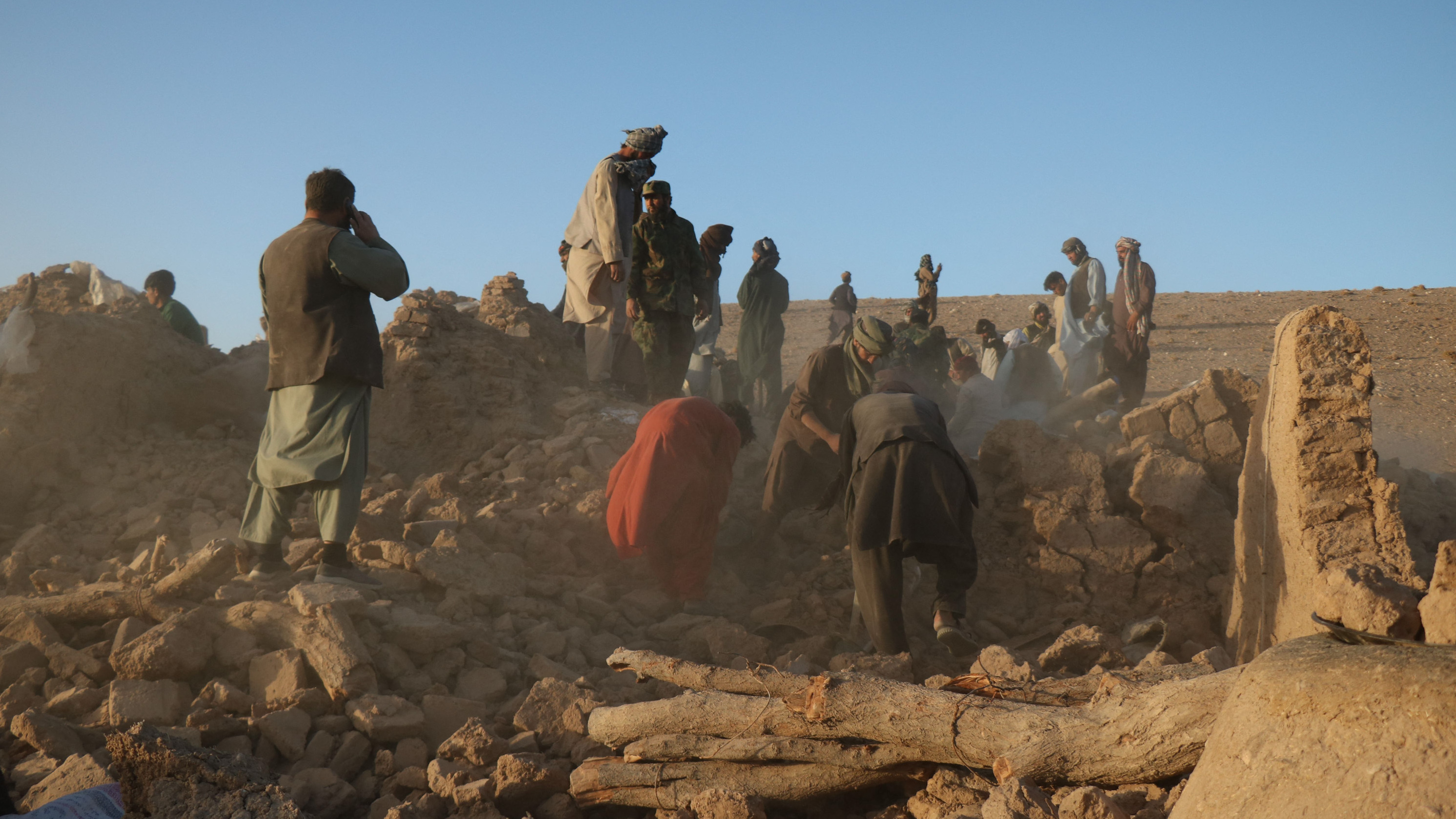 Afghan residents clear debris from a damaged house after an earthquake in the Zendeh Jan district of Herat province on Oct. 7.