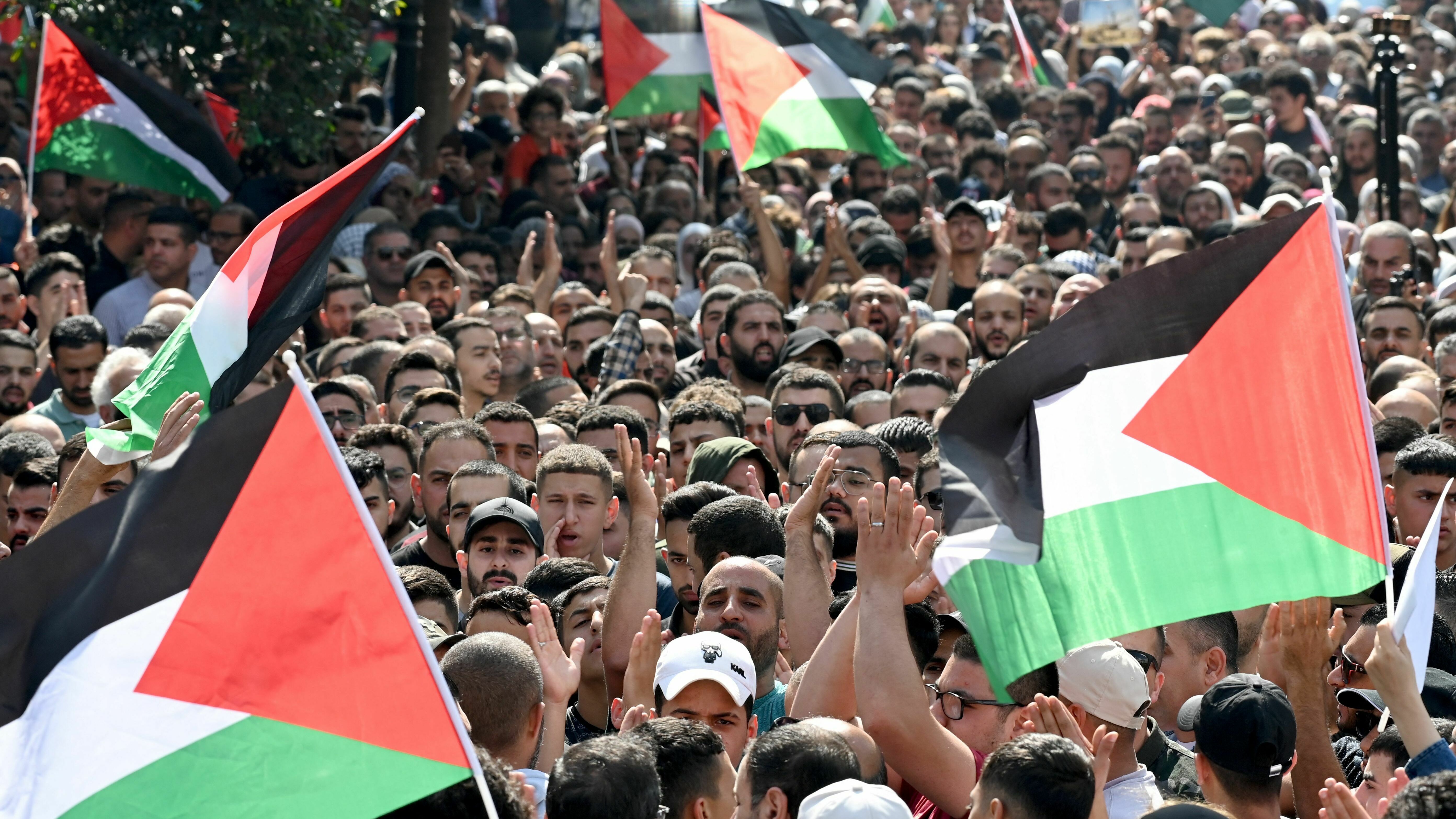 Palestinians wave the national flag during a demonstration in the city of Ramallah in the West Bank on Wednesday, Oct. 18, 2023, protesting an explosion on a Gaza hospital which killed hundreds a day earlier.