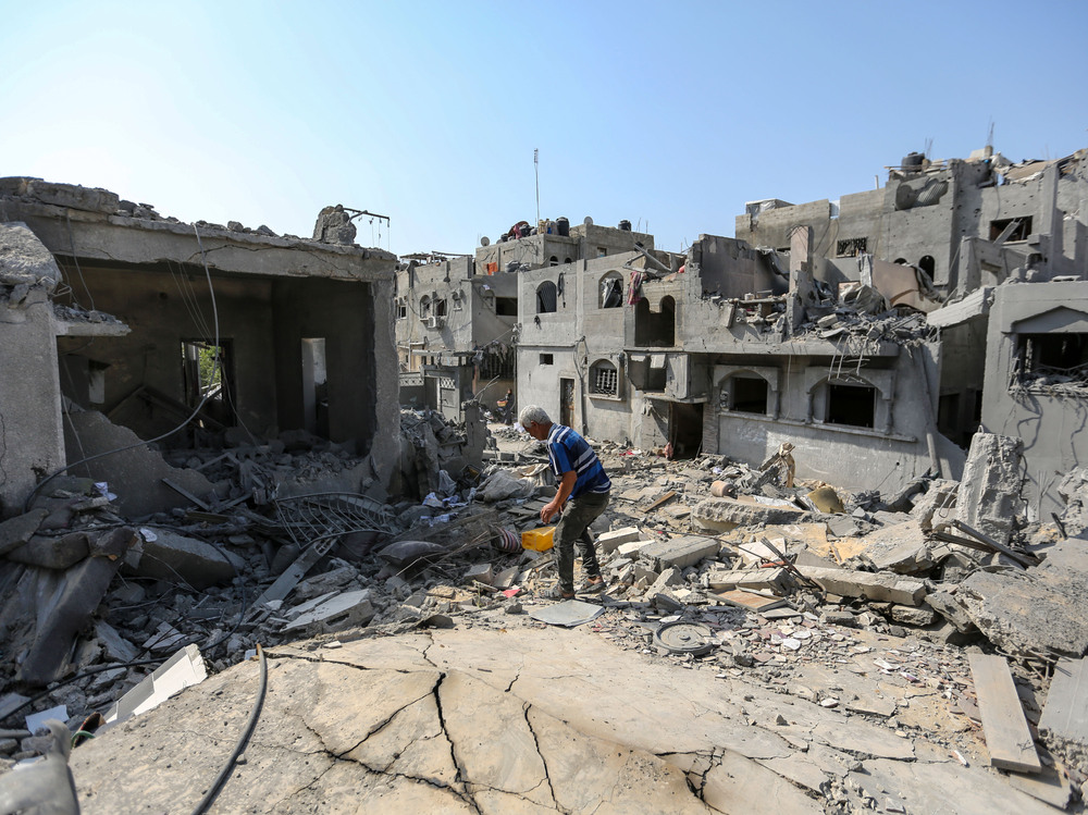 A local citizen searches through buildings which were destroyed during Israeli air raids in the southern Gaza Strip on Monday in Khan Younis, Gaza. (Getty Images)