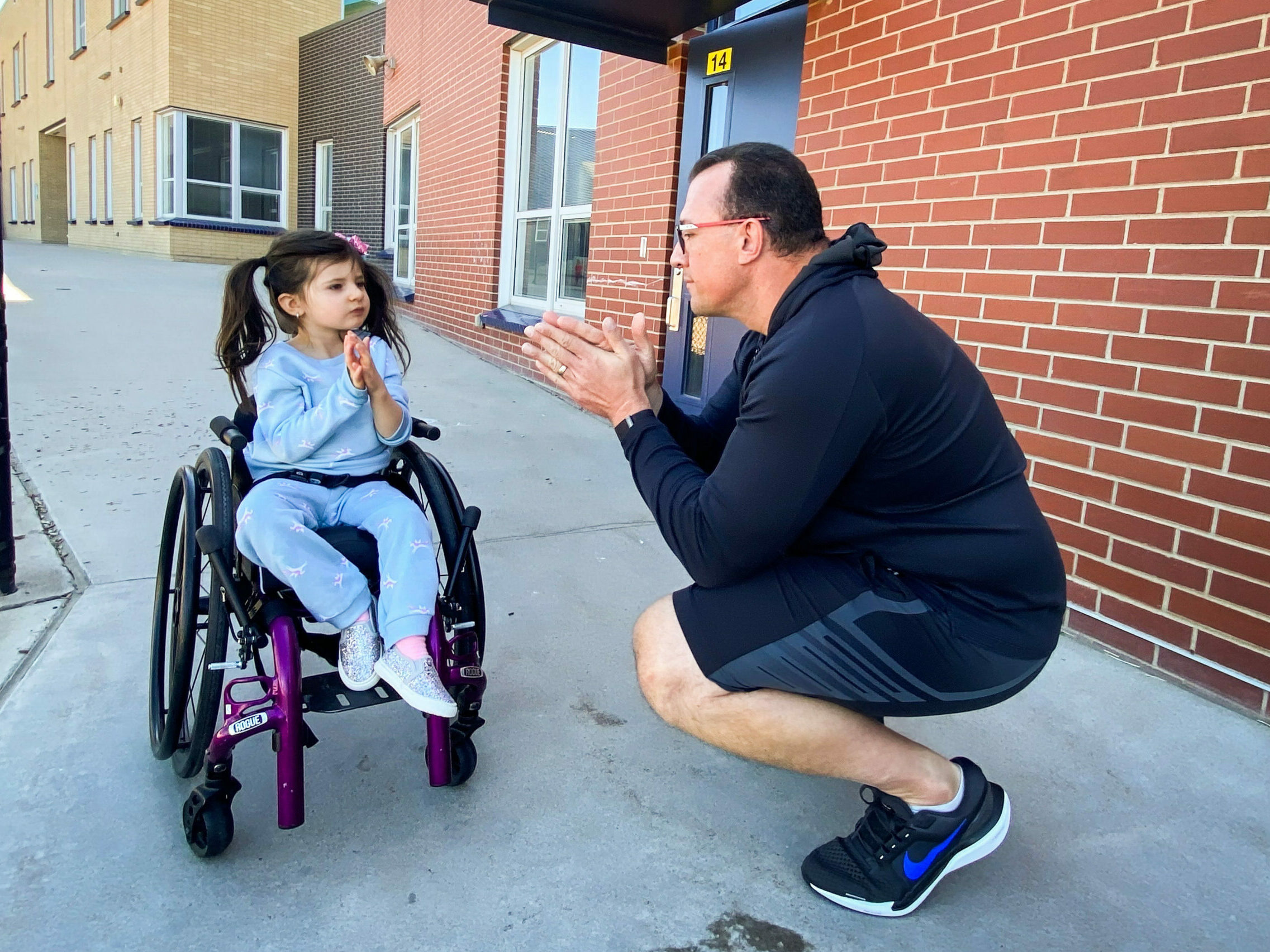 John Opp and his daughter Giuliana communicate with their hands at the Isabella Bird Community School in Denver. Opp said he's grateful for the universal pre-K program and the support it provides her. (CPR News)