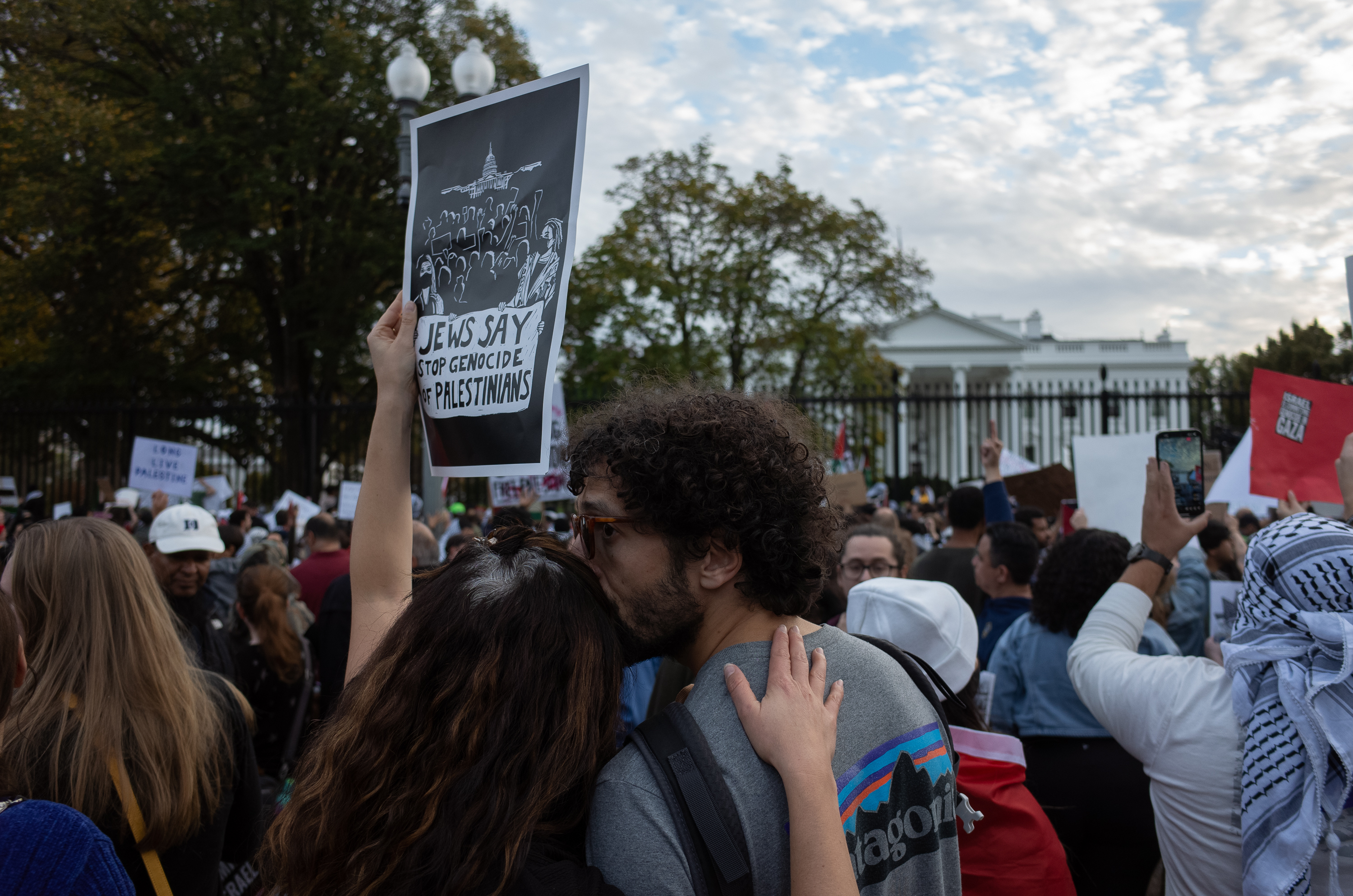 A couple holds a sign that reads "Jews say stop the genocide of Palestinians" Saturday in front of the White House in Washington, D.C.