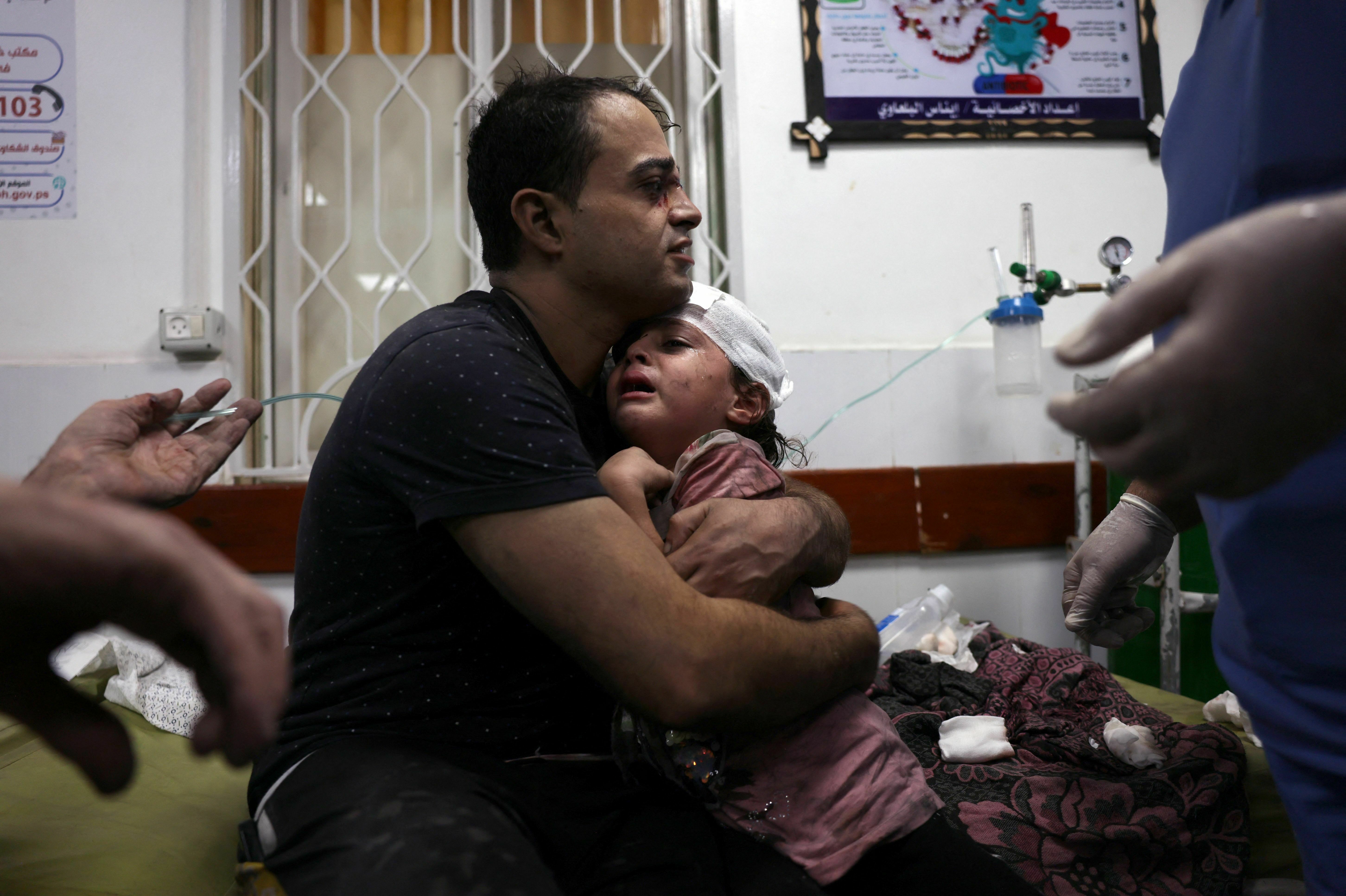 A Palestinian man cradles an injured child at the Najjar hospital following an Israeli airstrike on a home in Rafah, in the southern Gaza Strip, on Oct. 30.