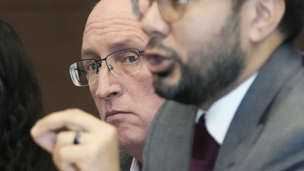 The father of a mass shooting suspect stands trial for helping him get a gun license